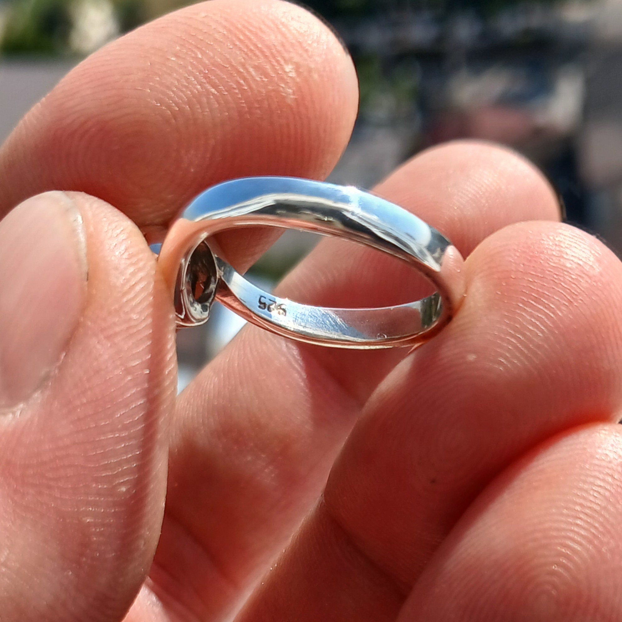A stunning Blue Zircon Ring set in polished sterling silver, featuring a round cut blue gemstone in a solitaire design.