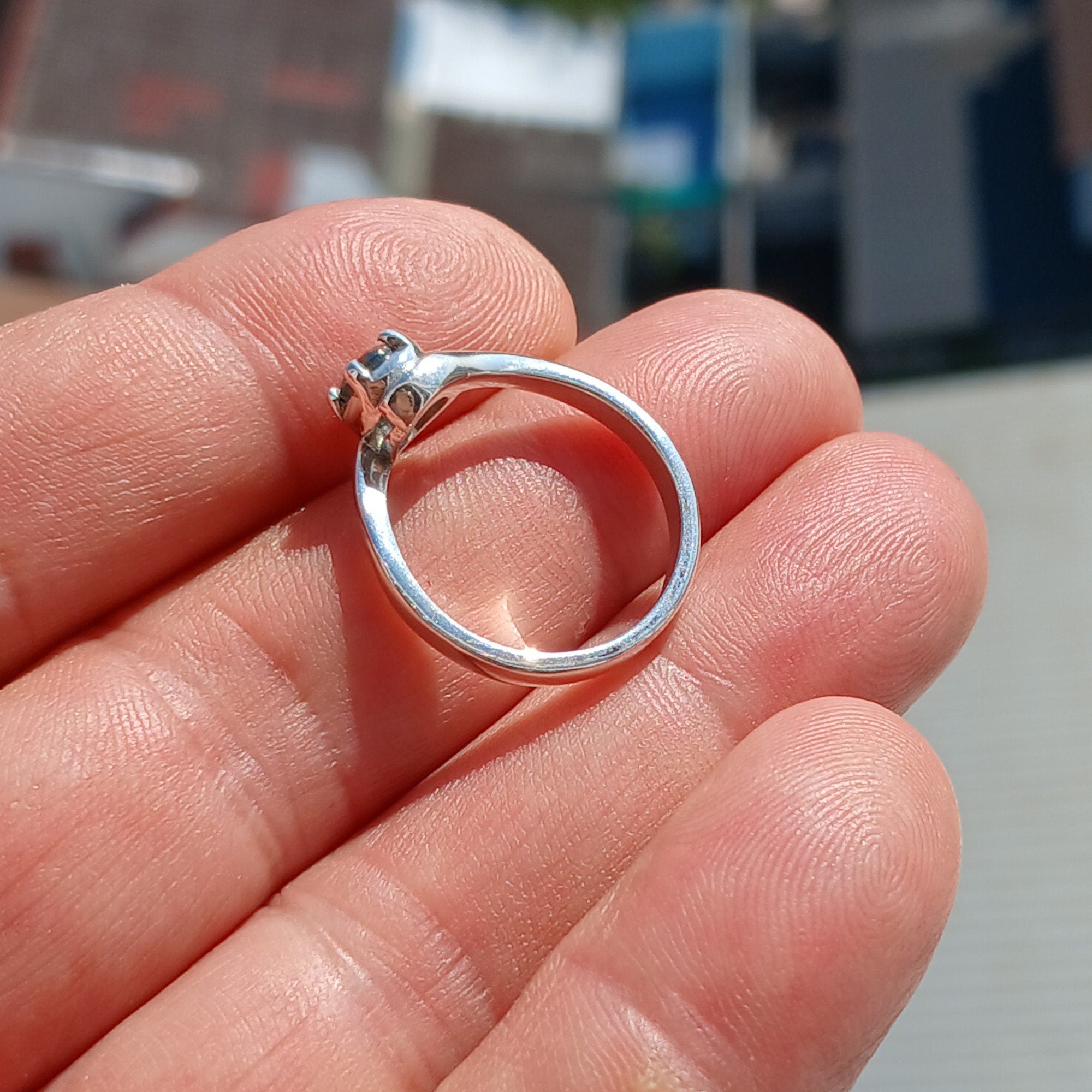 A stunning Blue Zircon Ring set in polished sterling silver, featuring a round cut blue gemstone in a solitaire design.