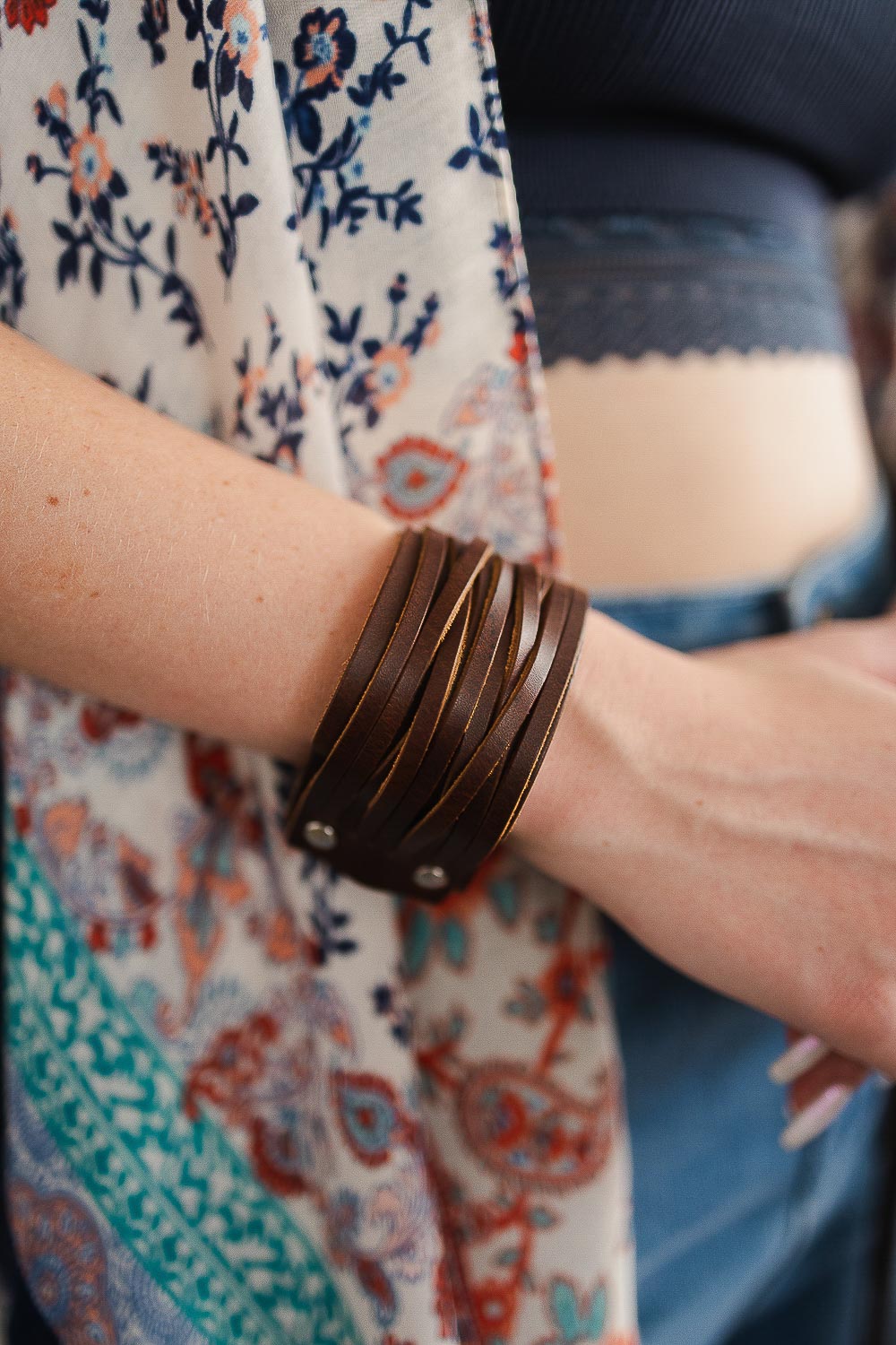 Braided leather cuff bracelet with adjustable clasp, showcasing intricate design and silver-toned clasp.