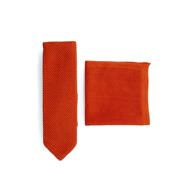 Burnt orange knitted tie and pocket square set displayed elegantly, showcasing the texture and color.