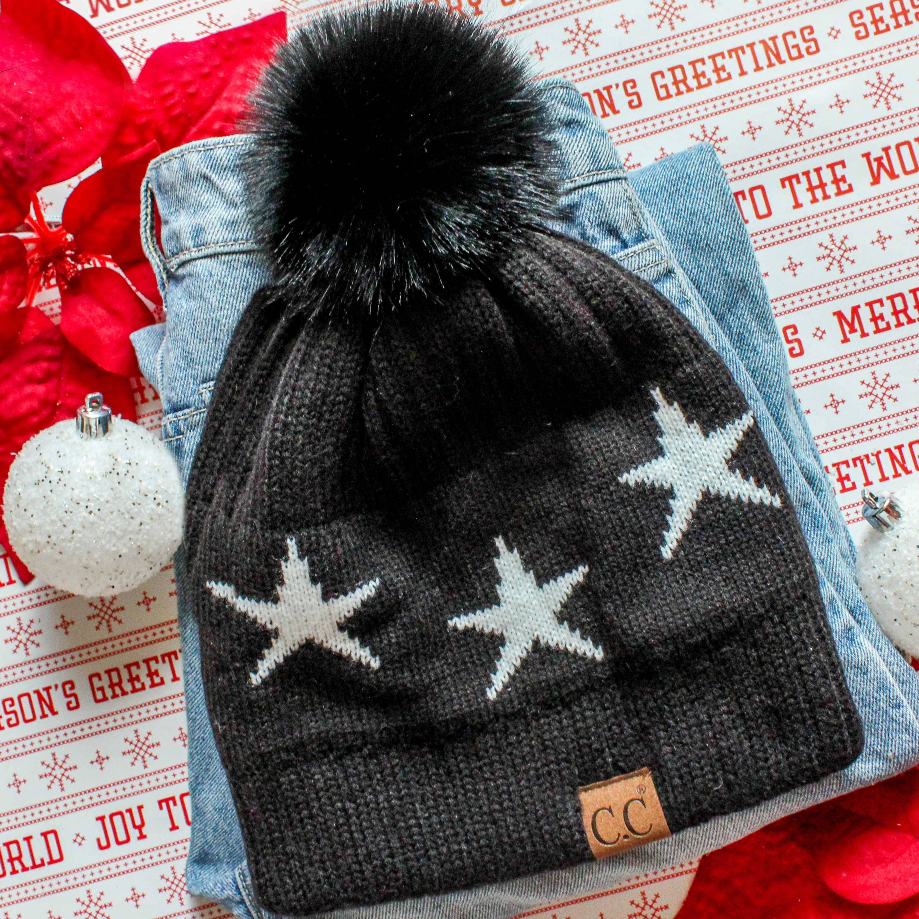 CC Beanie featuring a luxurious faux fur pom and trendy star pattern, perfect for stylish winter wear.