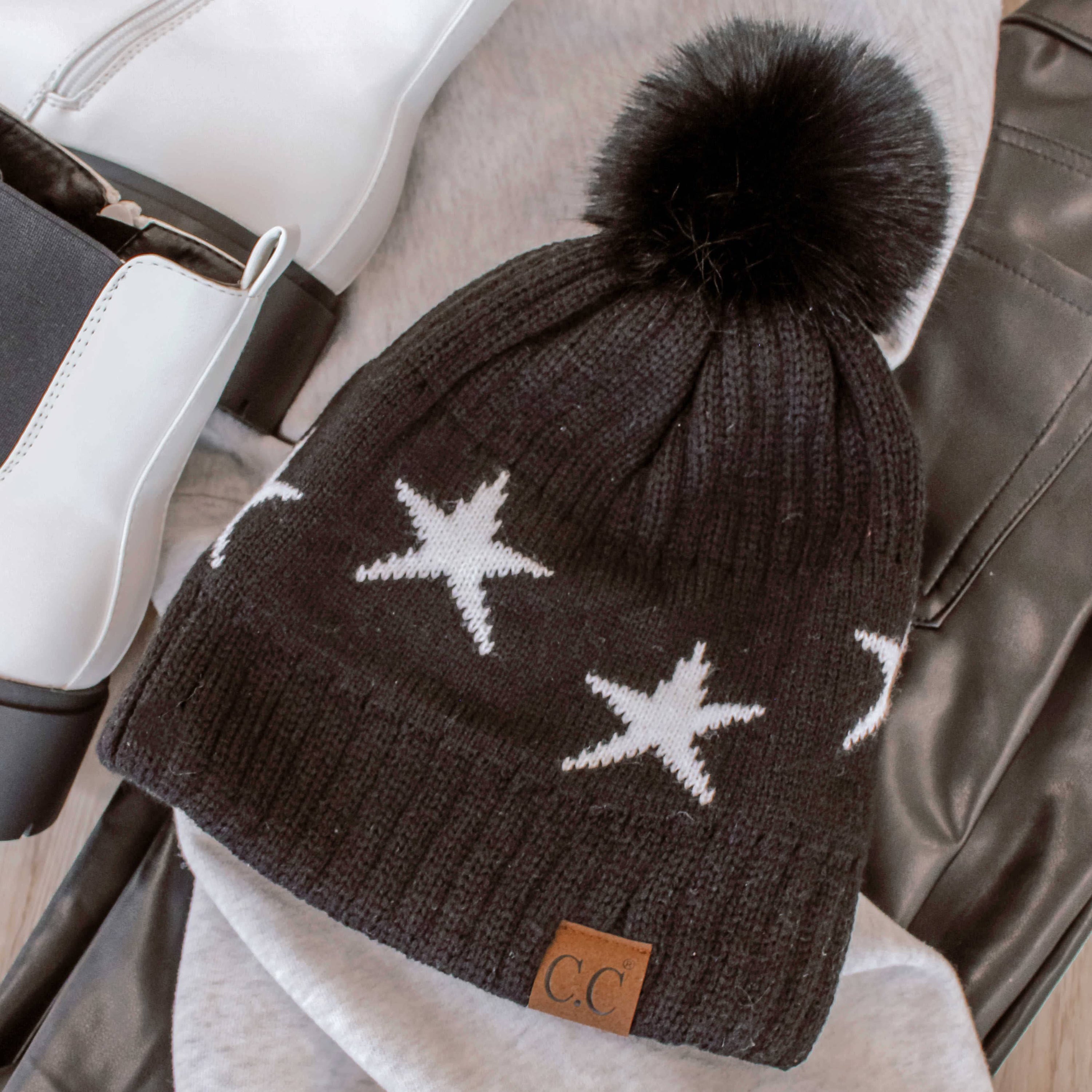 CC Beanie featuring a luxurious faux fur pom and trendy star pattern, perfect for stylish winter wear.