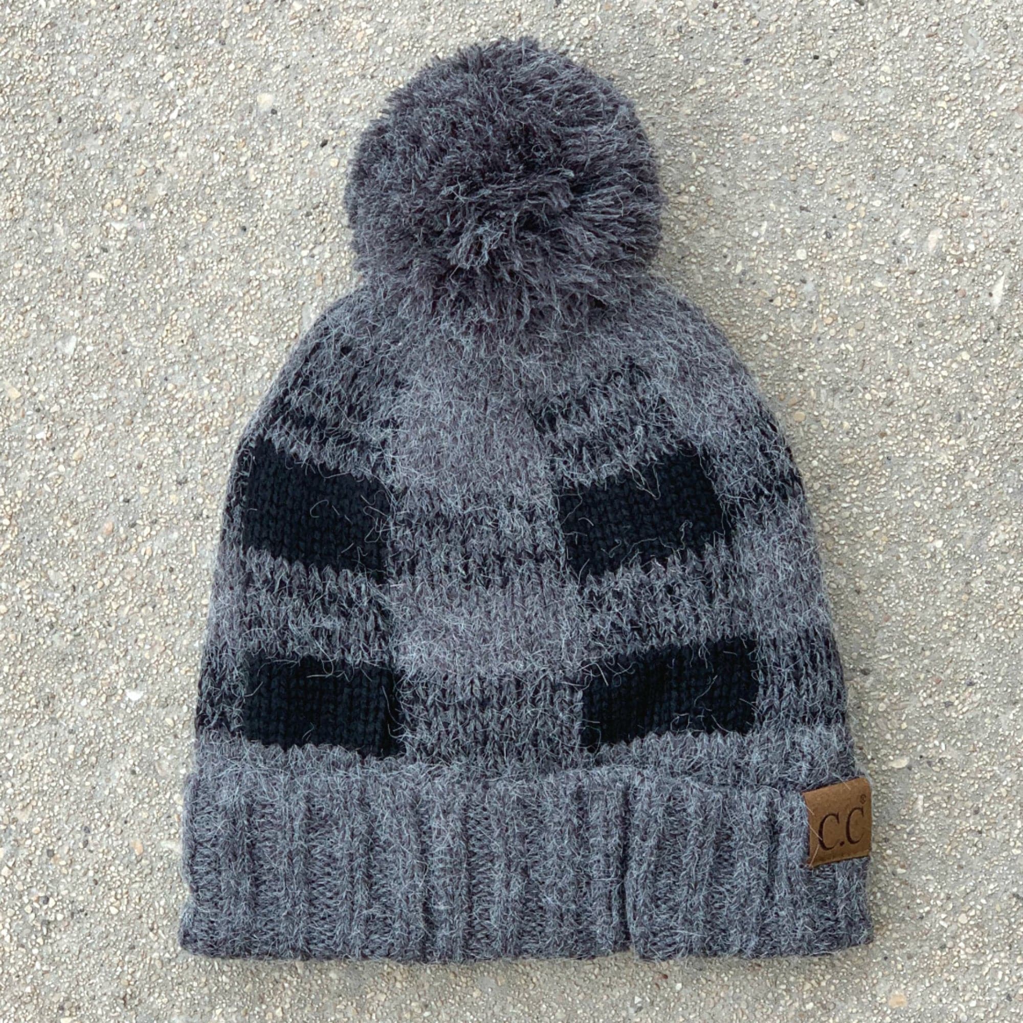 CC Buffalo Plaid Beanie with faux fur pom, fleece lined, showcasing a trendy buffalo check pattern.