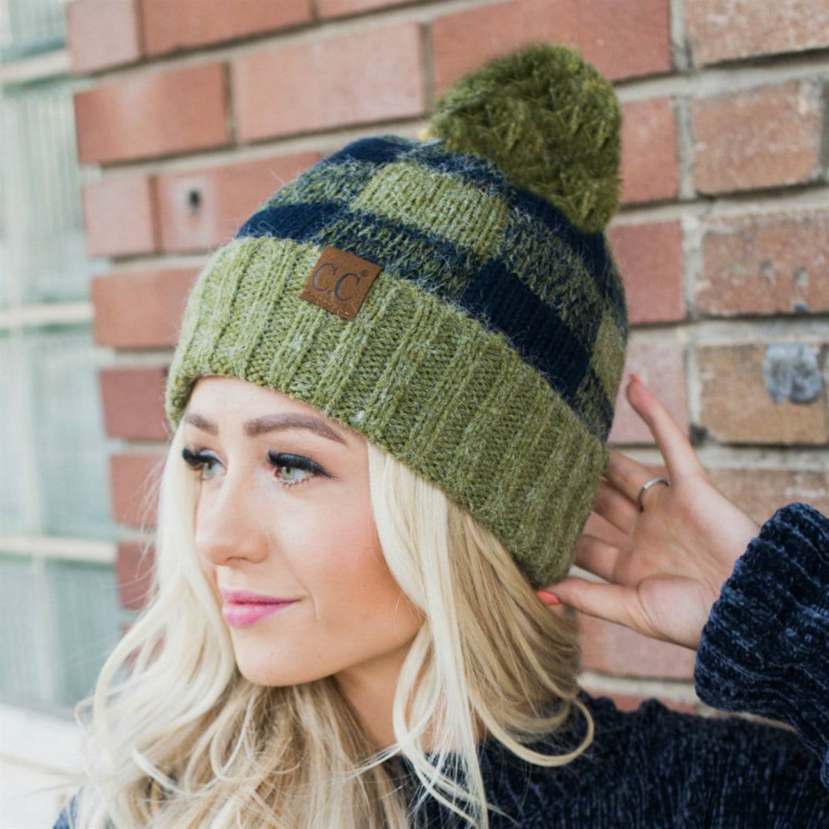 CC Buffalo Plaid Beanie with faux fur pom, fleece lined, showcasing a trendy buffalo check pattern.