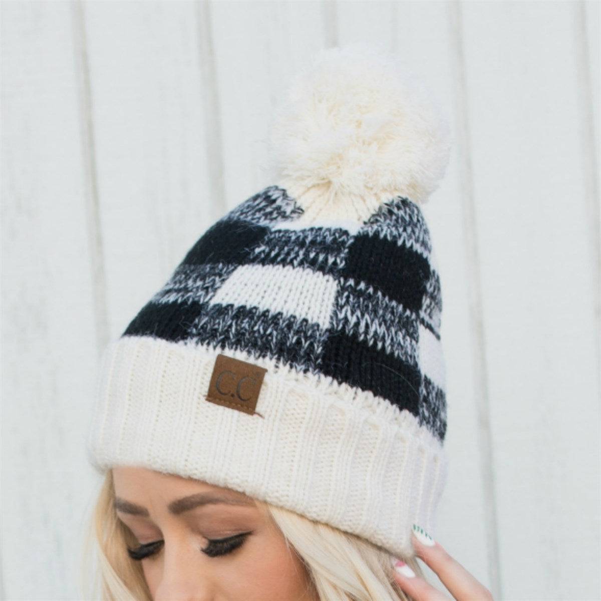 CC Buffalo Plaid Beanie with faux fur pom, fleece lined, showcasing a trendy buffalo check pattern.