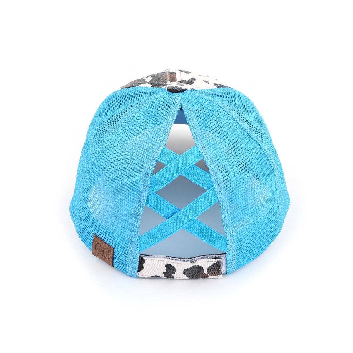 CC Cow Print Pony Hat featuring criss-cross elastic for ponytails, soft cotton material, and adjustable velcro strap.