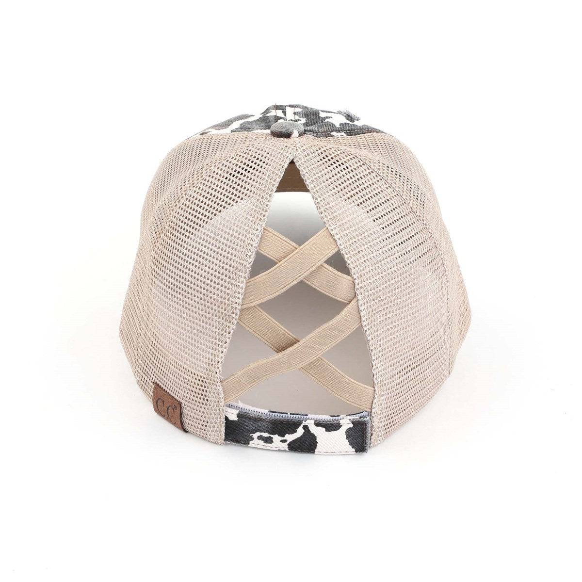 CC Cow Print Pony Hat featuring criss-cross elastic for ponytails, soft cotton material, and adjustable velcro strap.