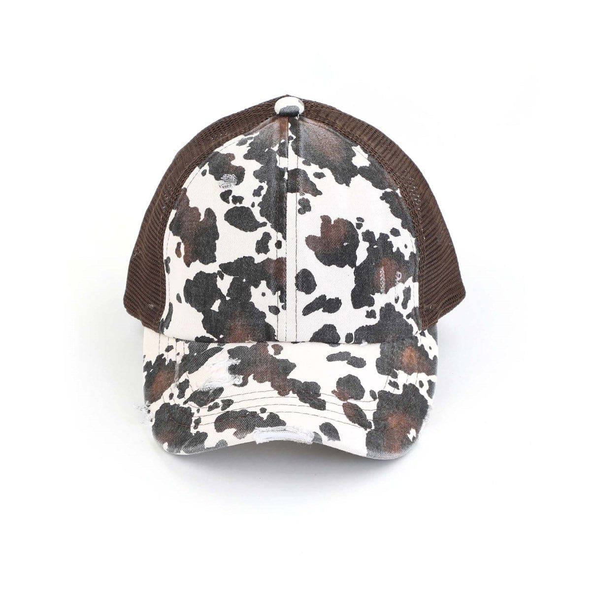 CC Cow Print Pony Hat featuring criss-cross elastic for ponytails, soft cotton material, and adjustable velcro strap.