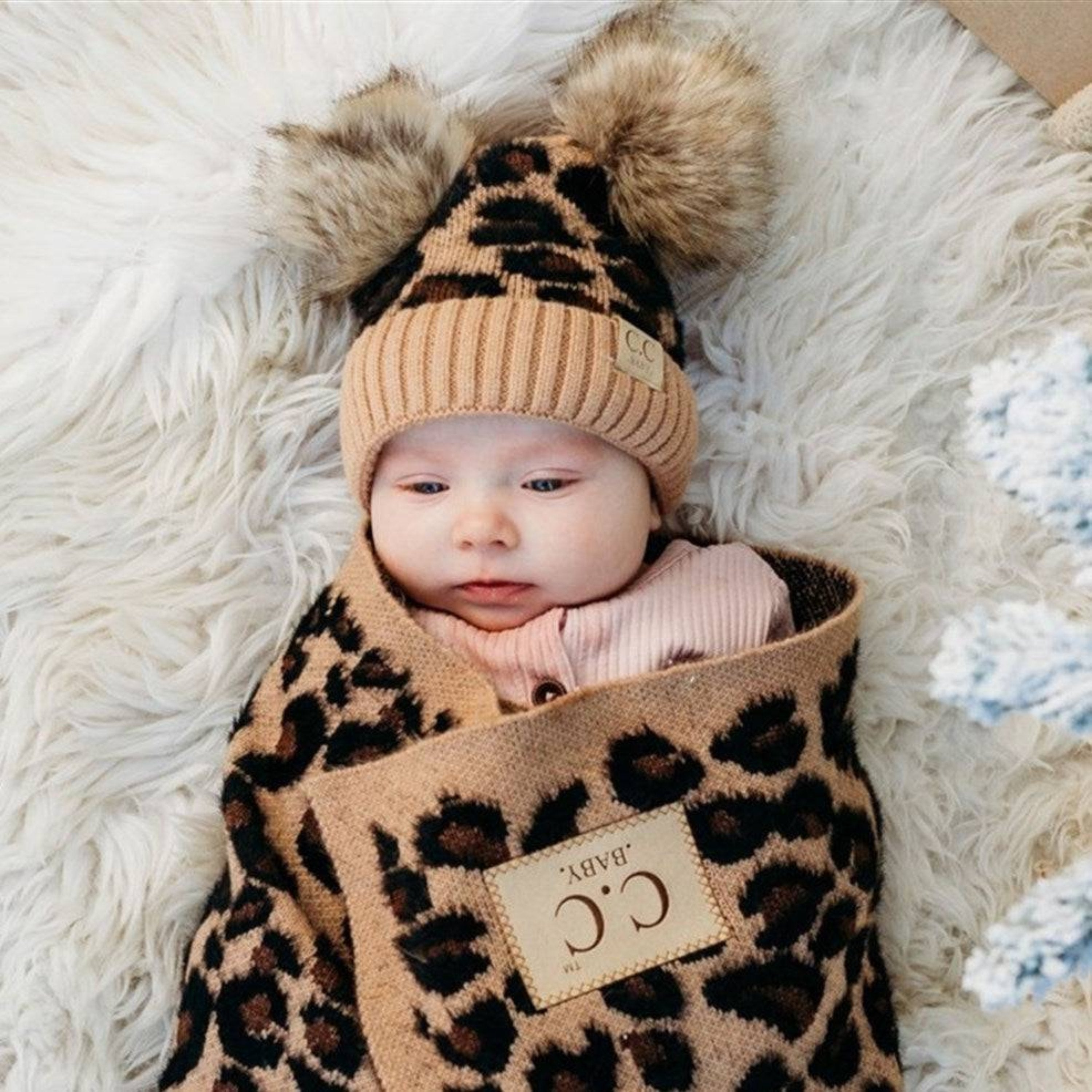 CC Double Pom Baby & Kids Leopard Beanie with fluffy faux fur poms and stylish leopard print design, perfect for keeping kids warm.