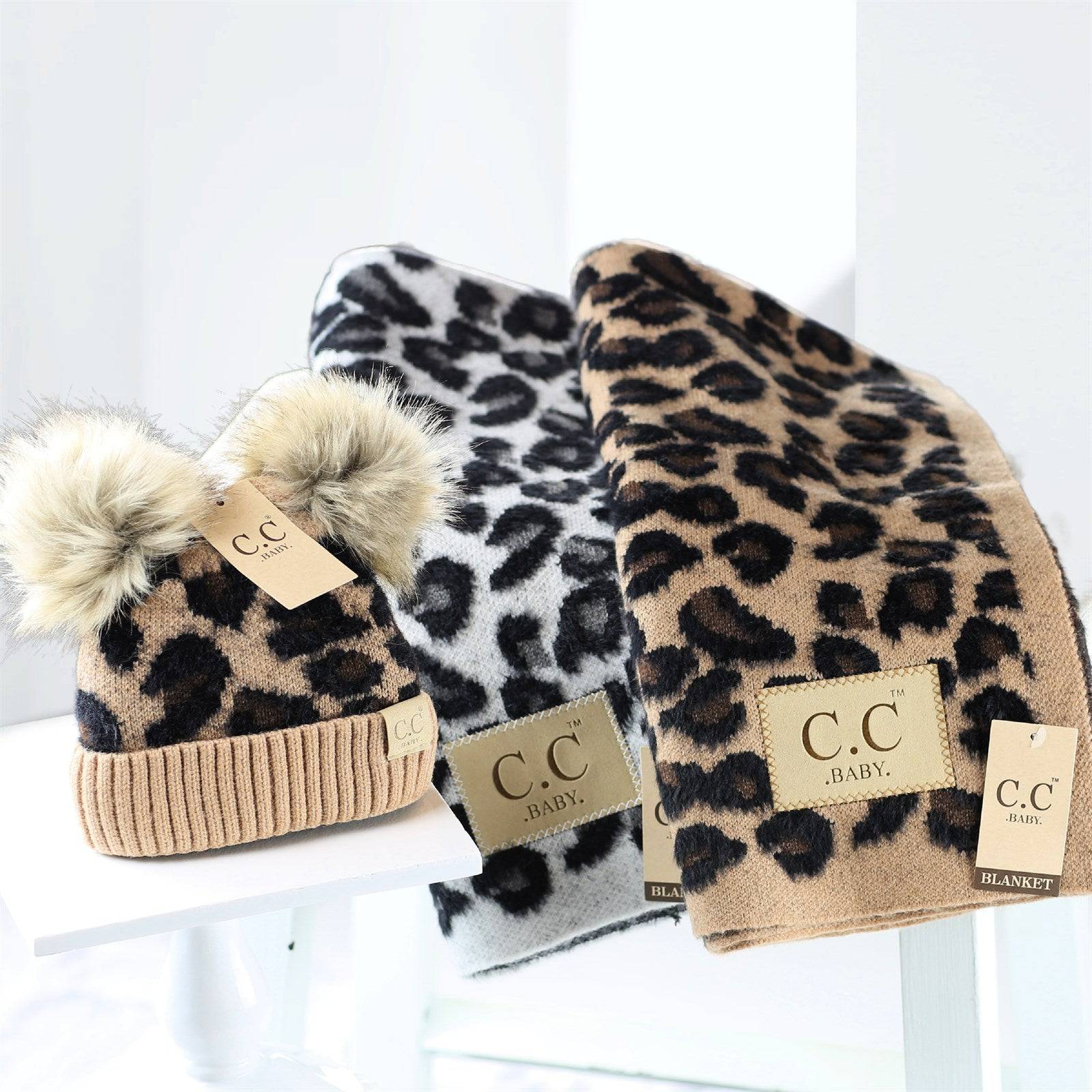 CC Double Pom Baby & Kids Leopard Beanie with fluffy faux fur poms and stylish leopard print design, perfect for keeping kids warm.