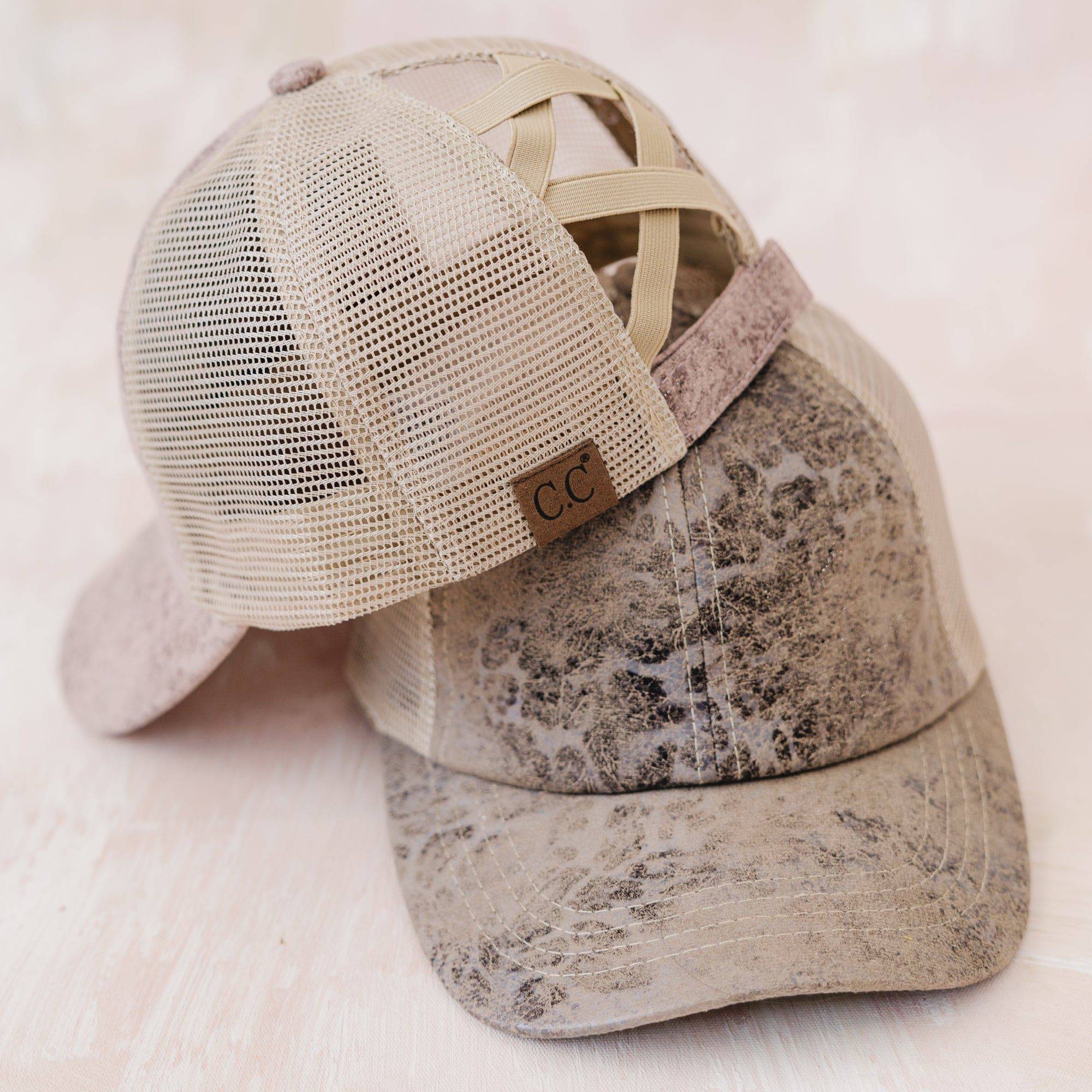 CC Faux Leather Hat in criss-cross style, designed for ponytails, featuring adjustable velcro closure and soft faux leather material.