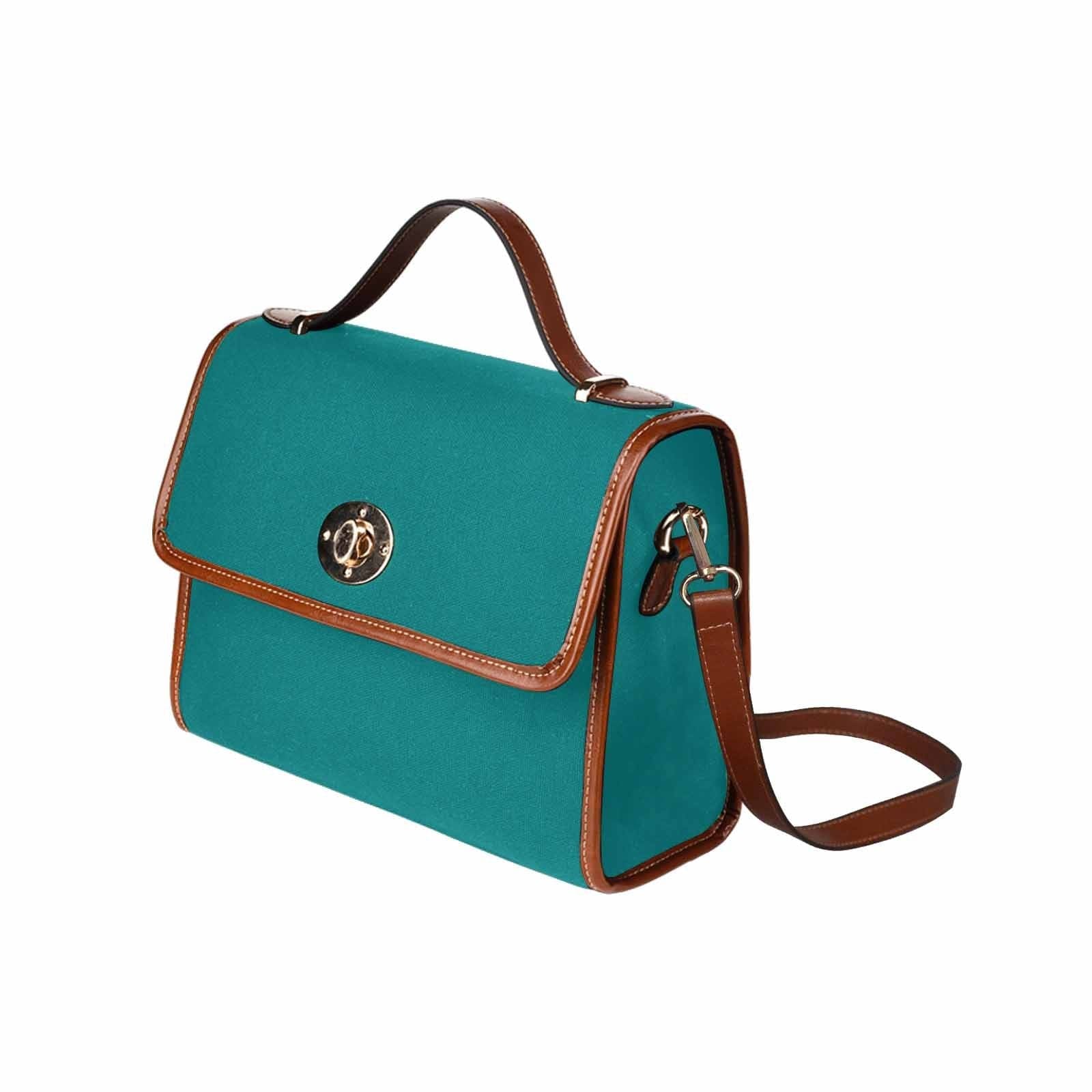 Dark teal green canvas handbag with brown crossbody strap, featuring two interior pockets and a zipper pocket.