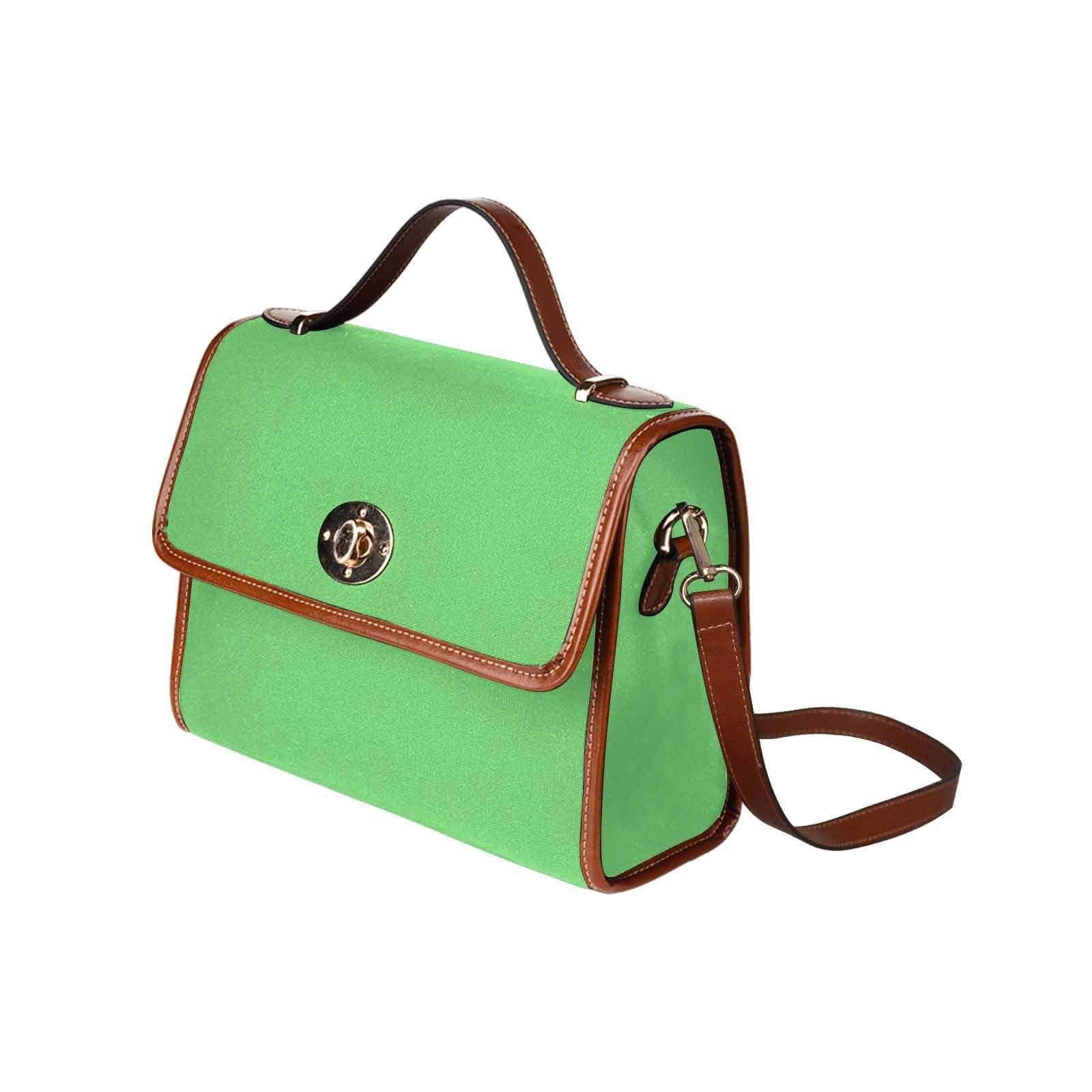 Pastel green waterproof canvas handbag with brown crossbody strap, featuring two interior pockets and a stylish design.