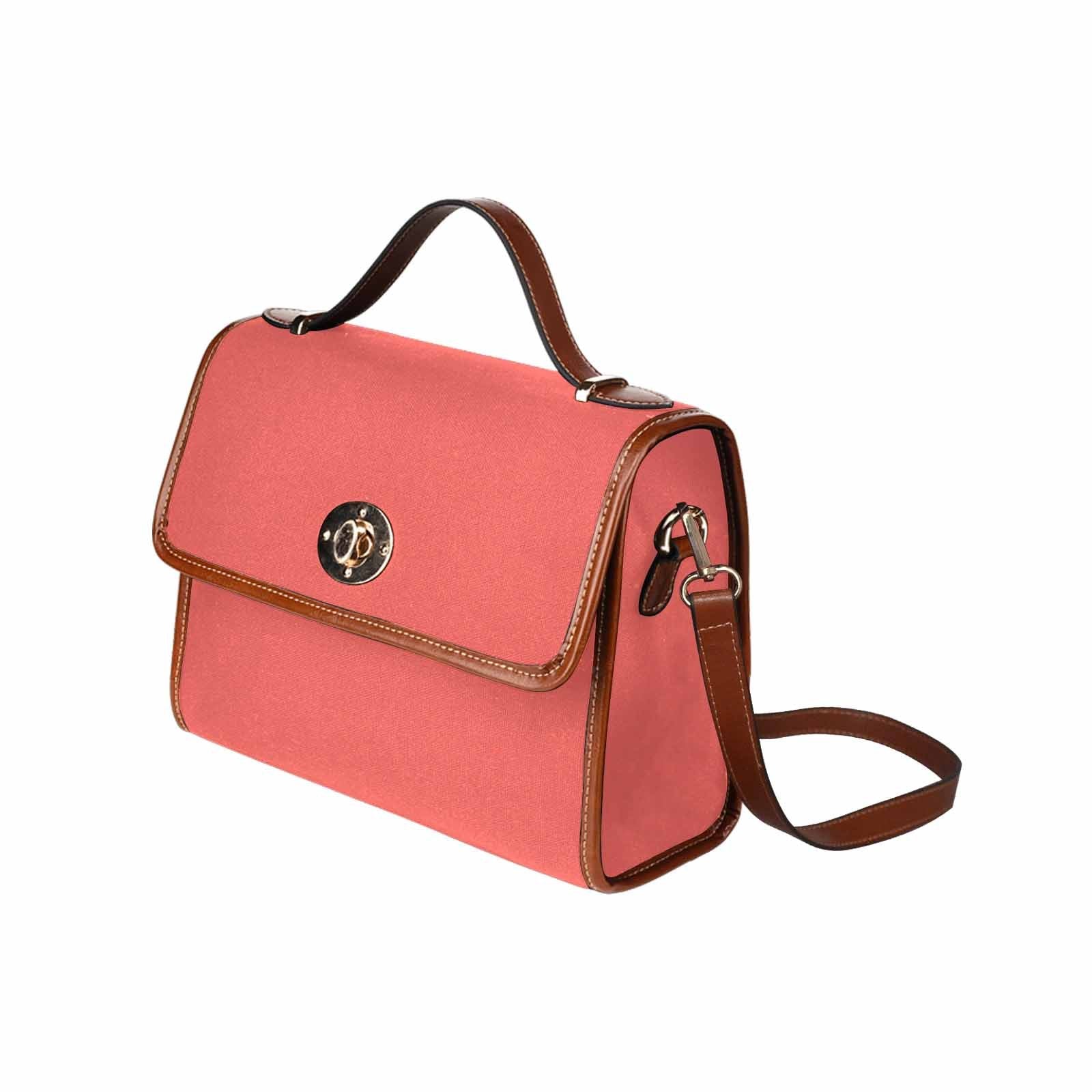 Pastel red waterproof canvas handbag with brown crossbody strap, featuring two interior pockets and a zipper pocket.