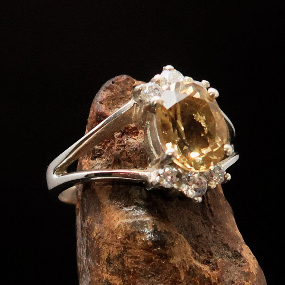 A stunning Citrine Silver Ring featuring an oval cut yellow gemstone and six sparkling white Cubic Zirconia stones, crafted from polished Sterling Silver.