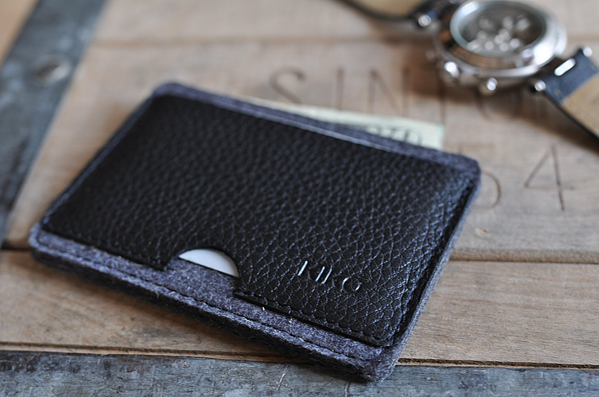 A stylish Combo Card Case made from wool felt and vegetable tanned cowhide leather, featuring rustic heat burnished details and two slots for cards and cash.