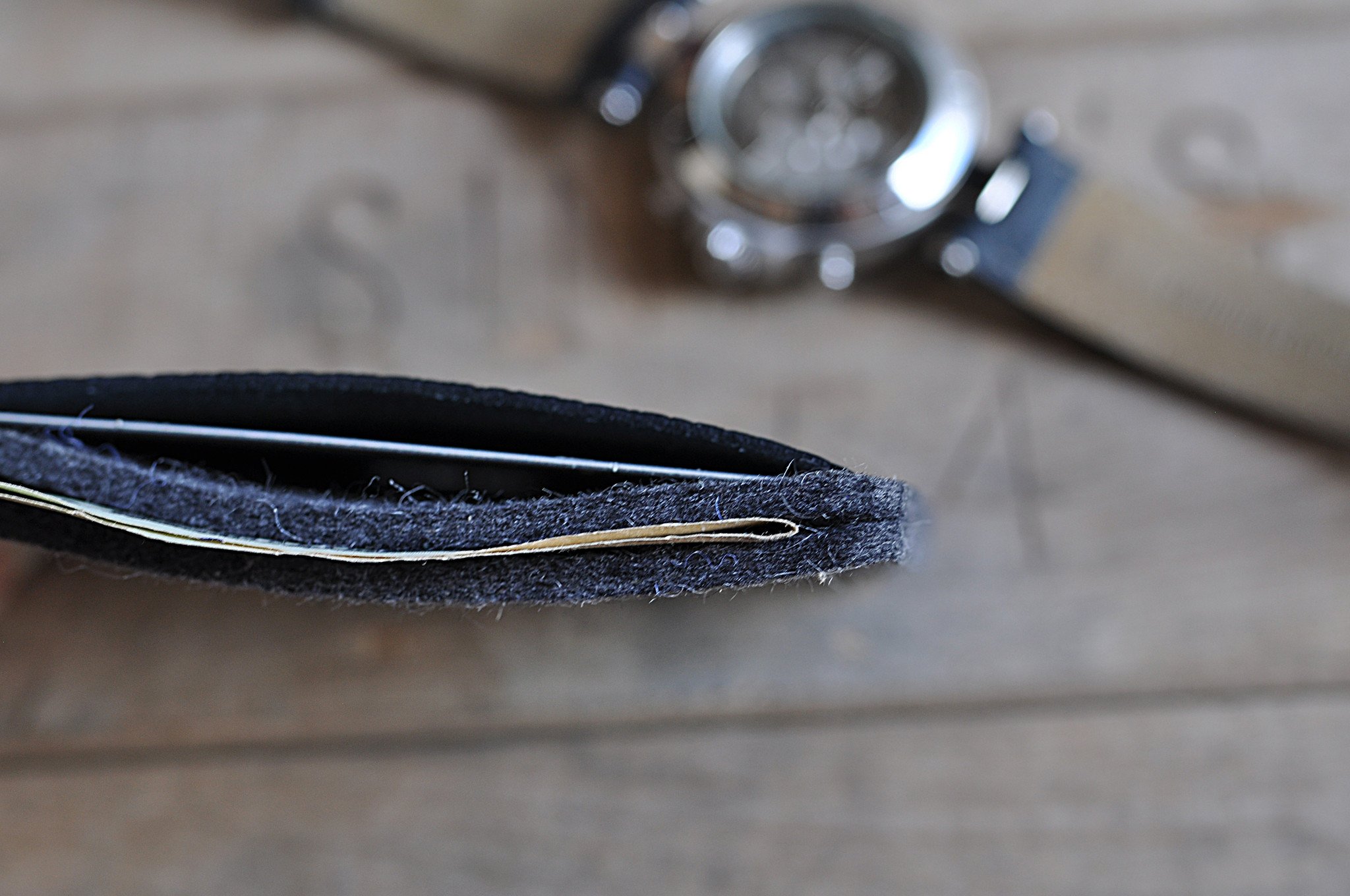 A stylish Combo Card Case made from wool felt and vegetable tanned cowhide leather, featuring rustic heat burnished details and two slots for cards and cash.