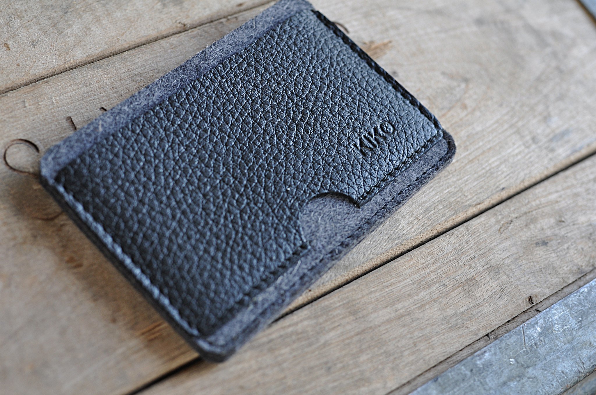 A stylish Combo Card Case made from wool felt and vegetable tanned cowhide leather, featuring rustic heat burnished details and two slots for cards and cash.