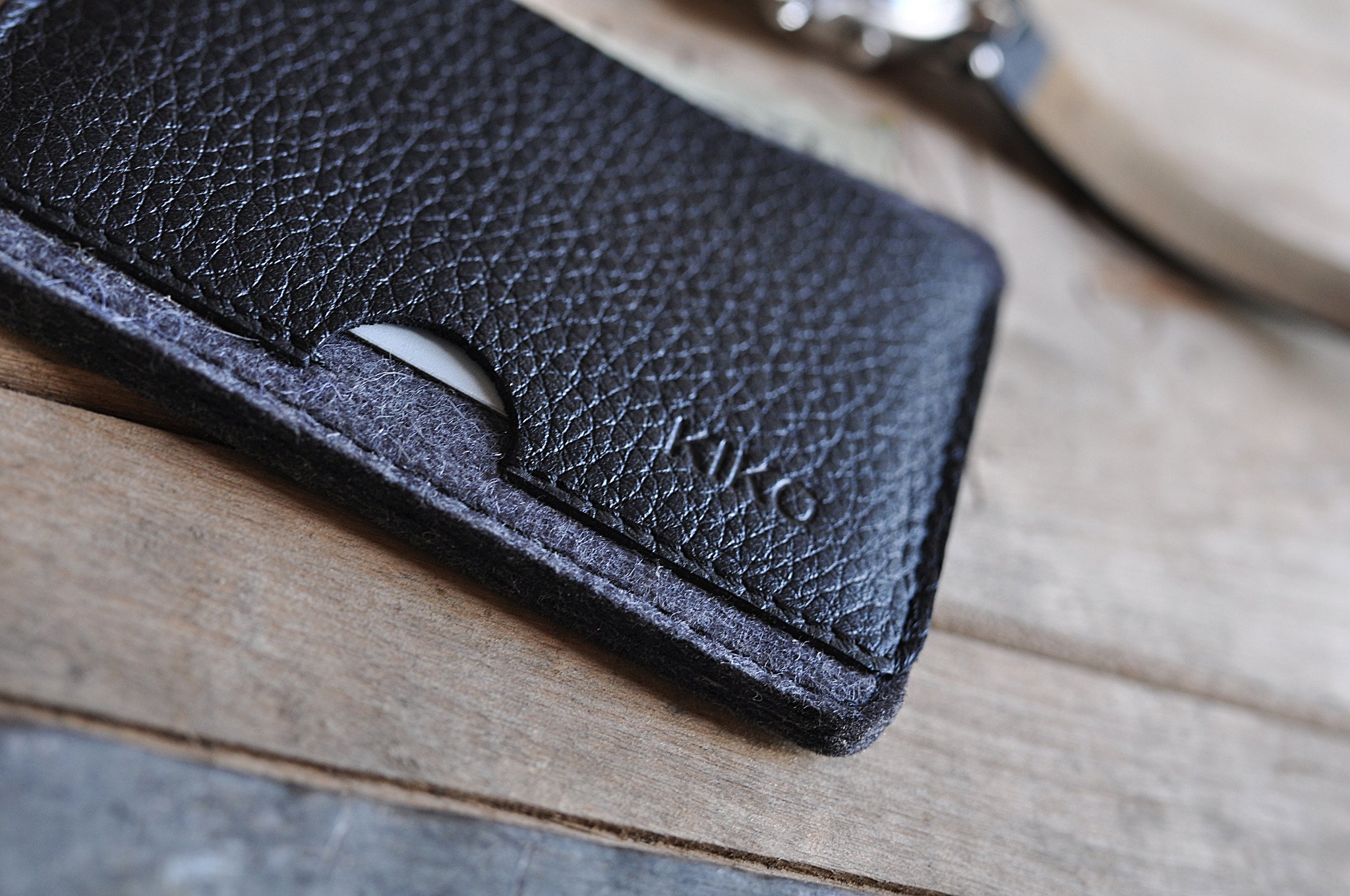 A stylish Combo Card Case made from wool felt and vegetable tanned cowhide leather, featuring rustic heat burnished details and two slots for cards and cash.