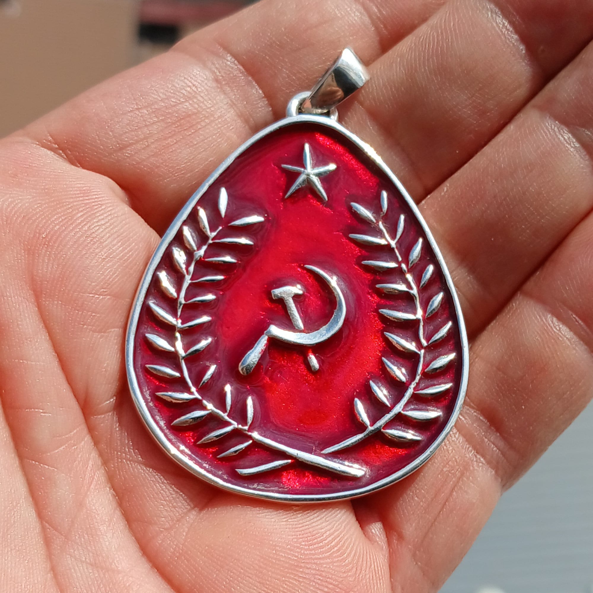 Communist Crest Pendant made of sterling silver with red enamel inlay, featuring hammer and sickle symbol in a pear-shaped design.