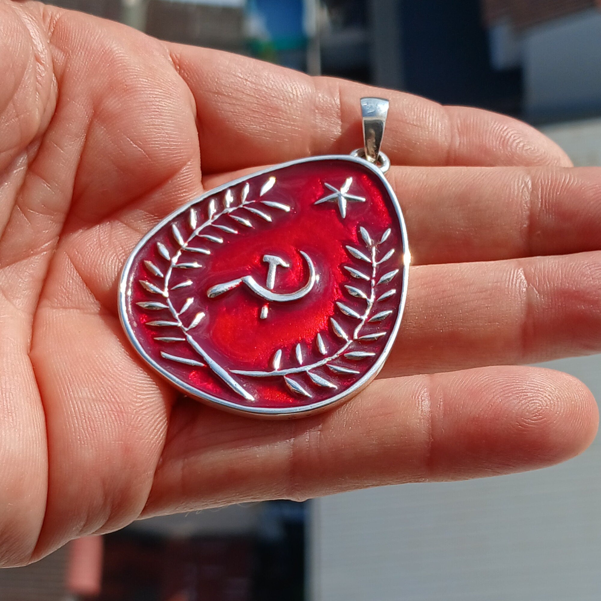 Communist Crest Pendant made of sterling silver with red enamel inlay, featuring hammer and sickle symbol in a pear-shaped design.