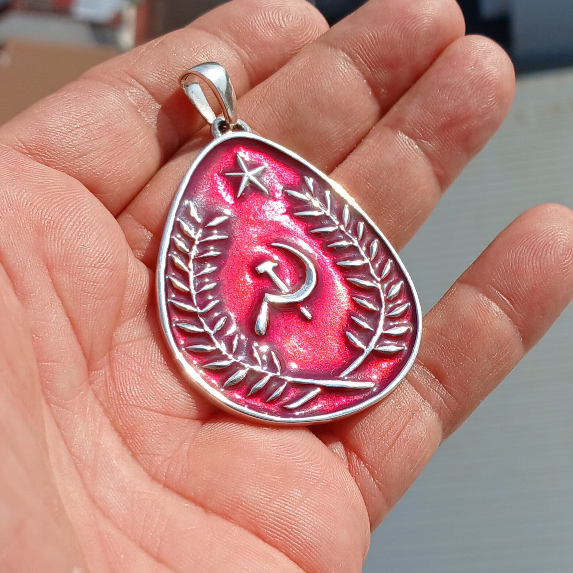 Communist Crest Pendant made of sterling silver with red enamel inlay, featuring hammer and sickle symbol in a pear-shaped design.