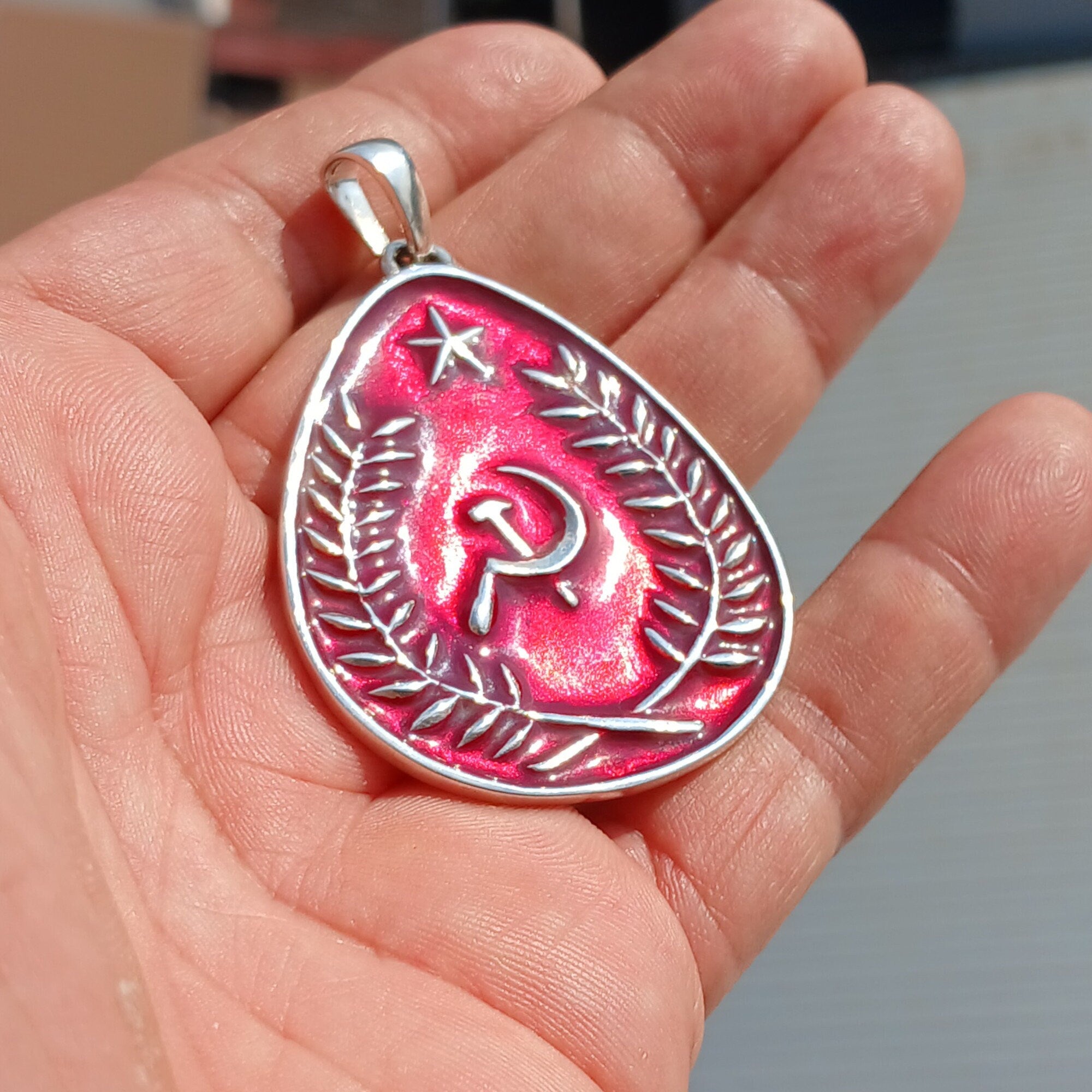 Communist Crest Pendant made of sterling silver with red enamel inlay, featuring hammer and sickle symbol in a pear-shaped design.
