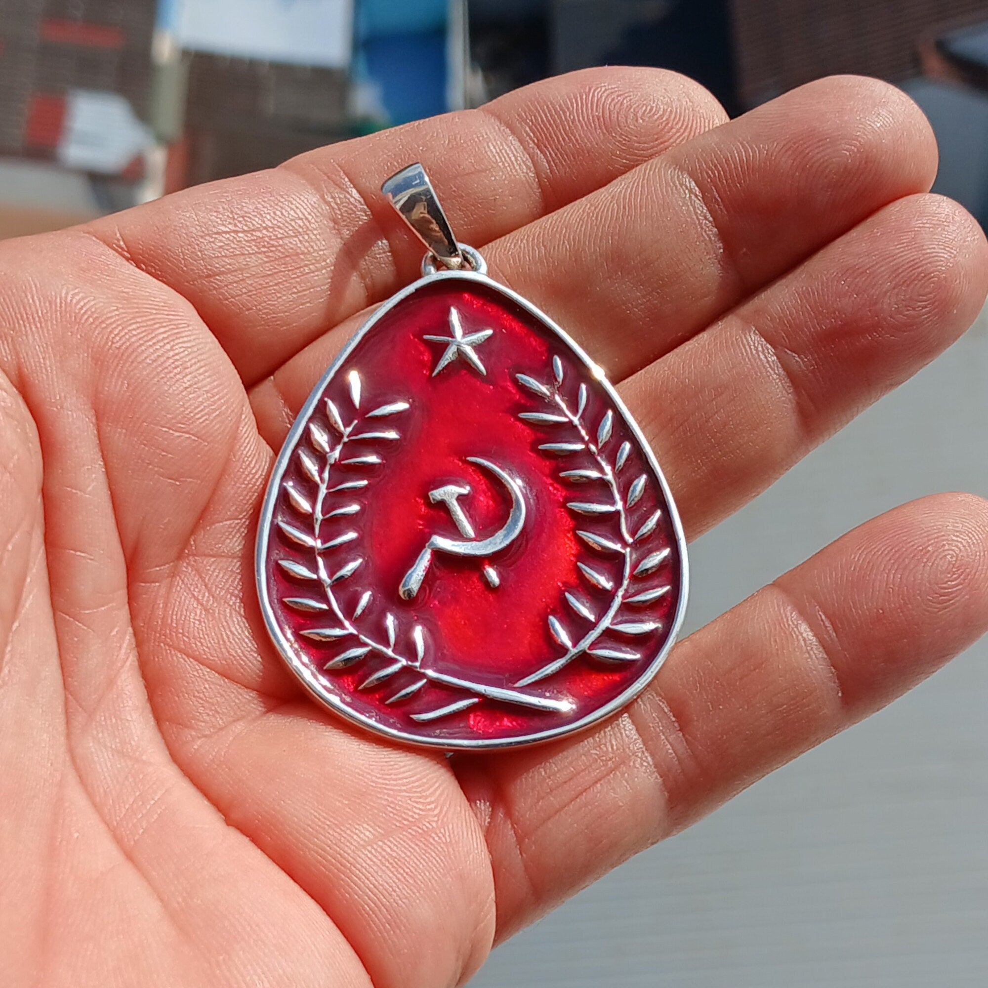 Communist Crest Pendant made of sterling silver with red enamel inlay, featuring hammer and sickle symbol in a pear-shaped design.