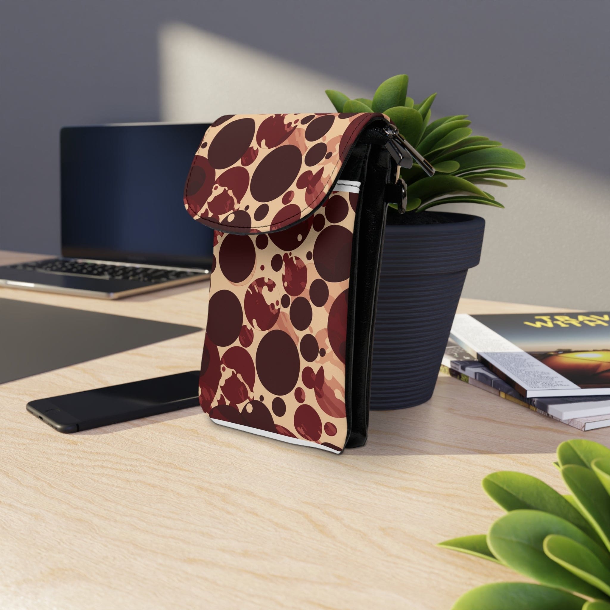 Burgundy and beige circular crossbody bag with adjustable strap and flip-up compartments for phone and cards.