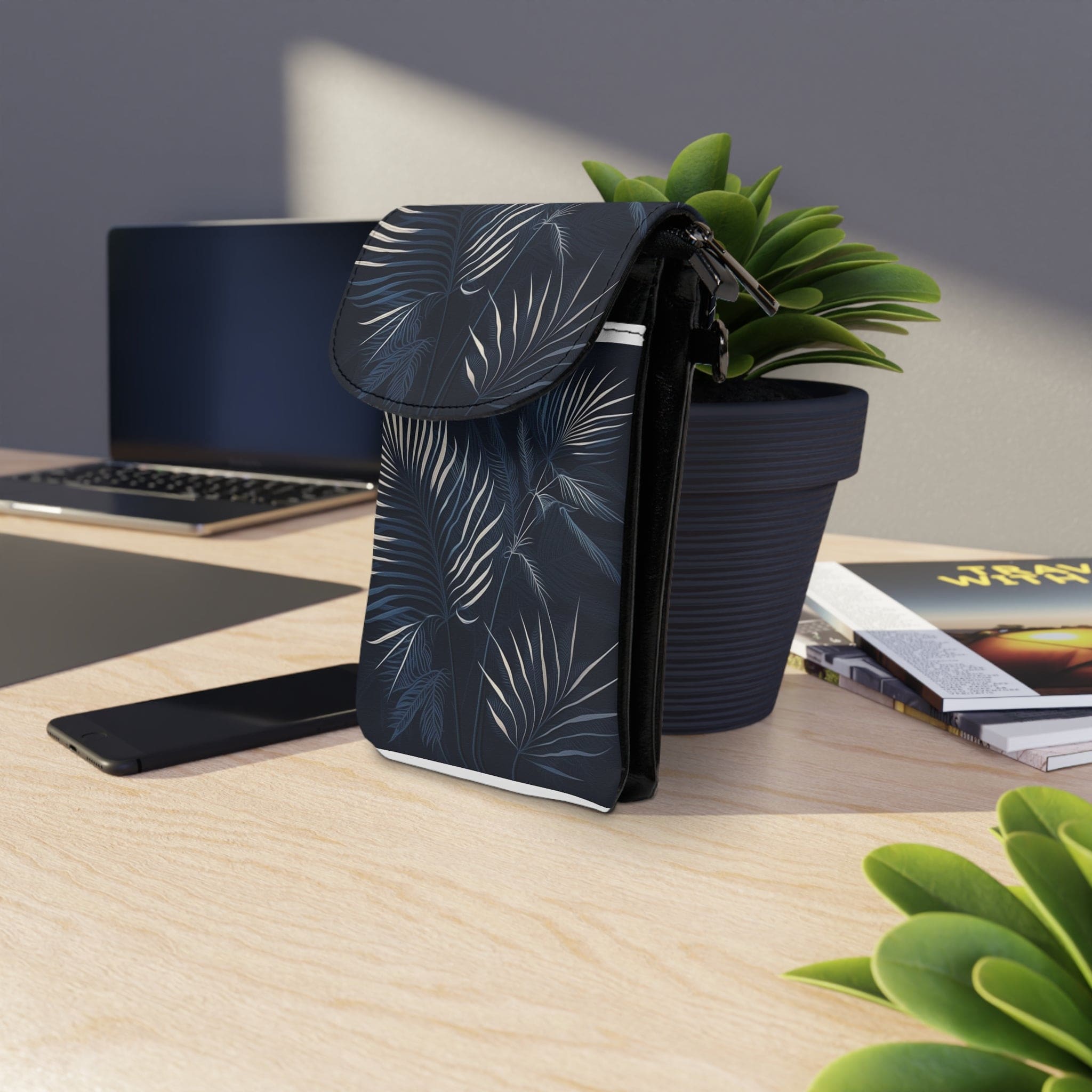 A stylish small crossbody bag featuring white line art palm trees on a navy blue background, perfect for carrying a cell phone and essentials.