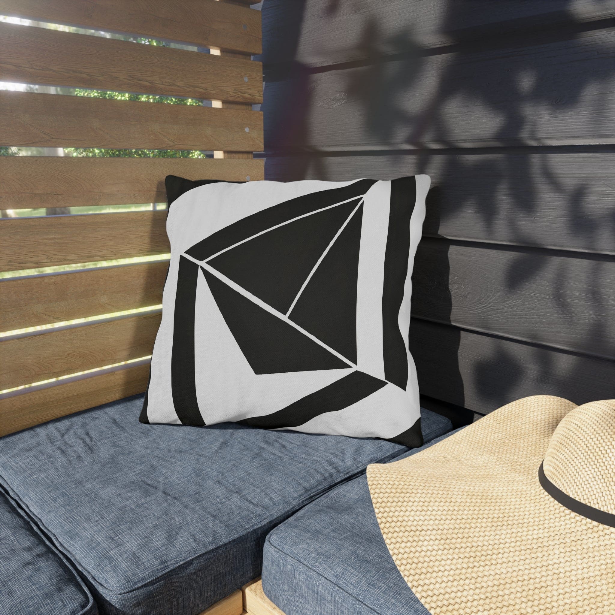 Decorative indoor/outdoor pillow featuring a black and white geometric pattern, ideal for enhancing outdoor spaces.