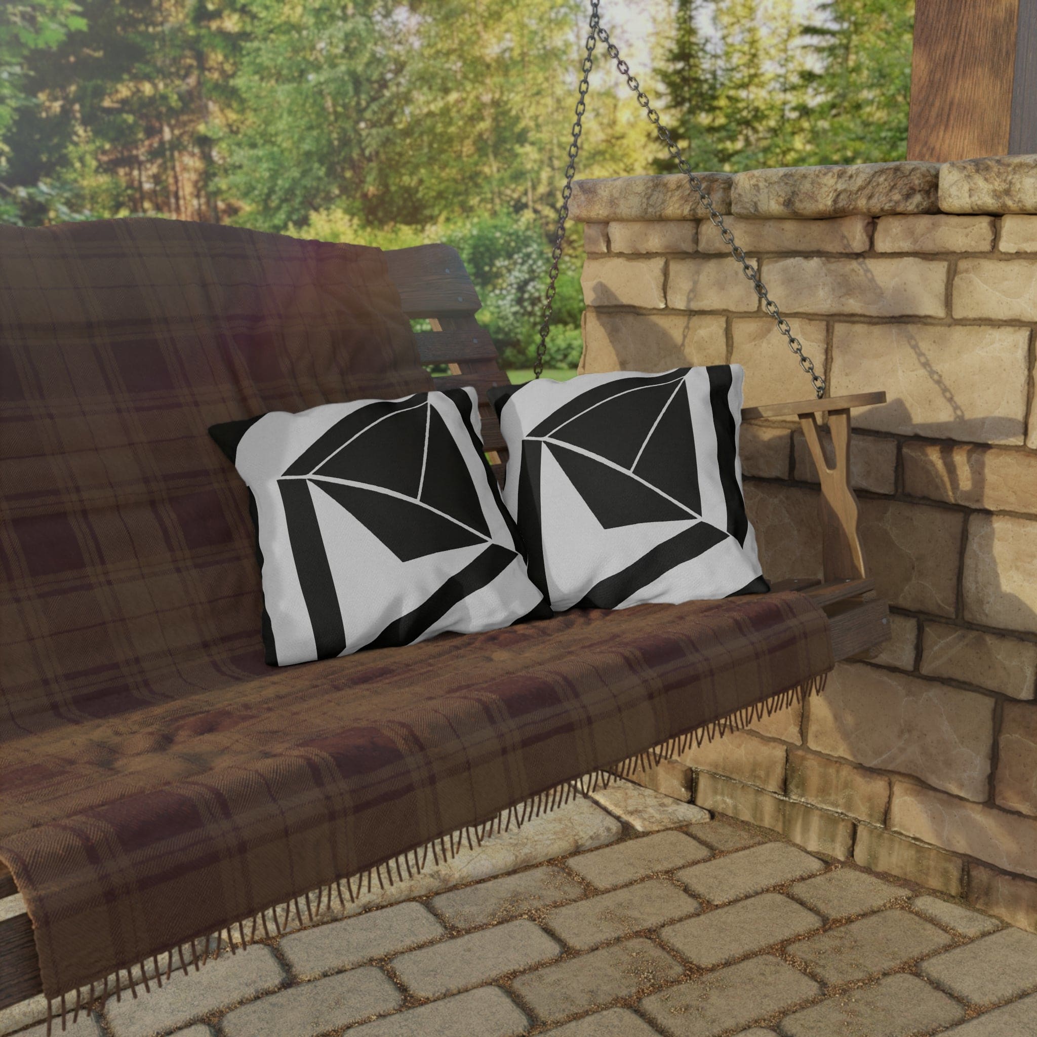 Decorative indoor/outdoor pillow featuring a black and white geometric pattern, ideal for enhancing outdoor spaces.