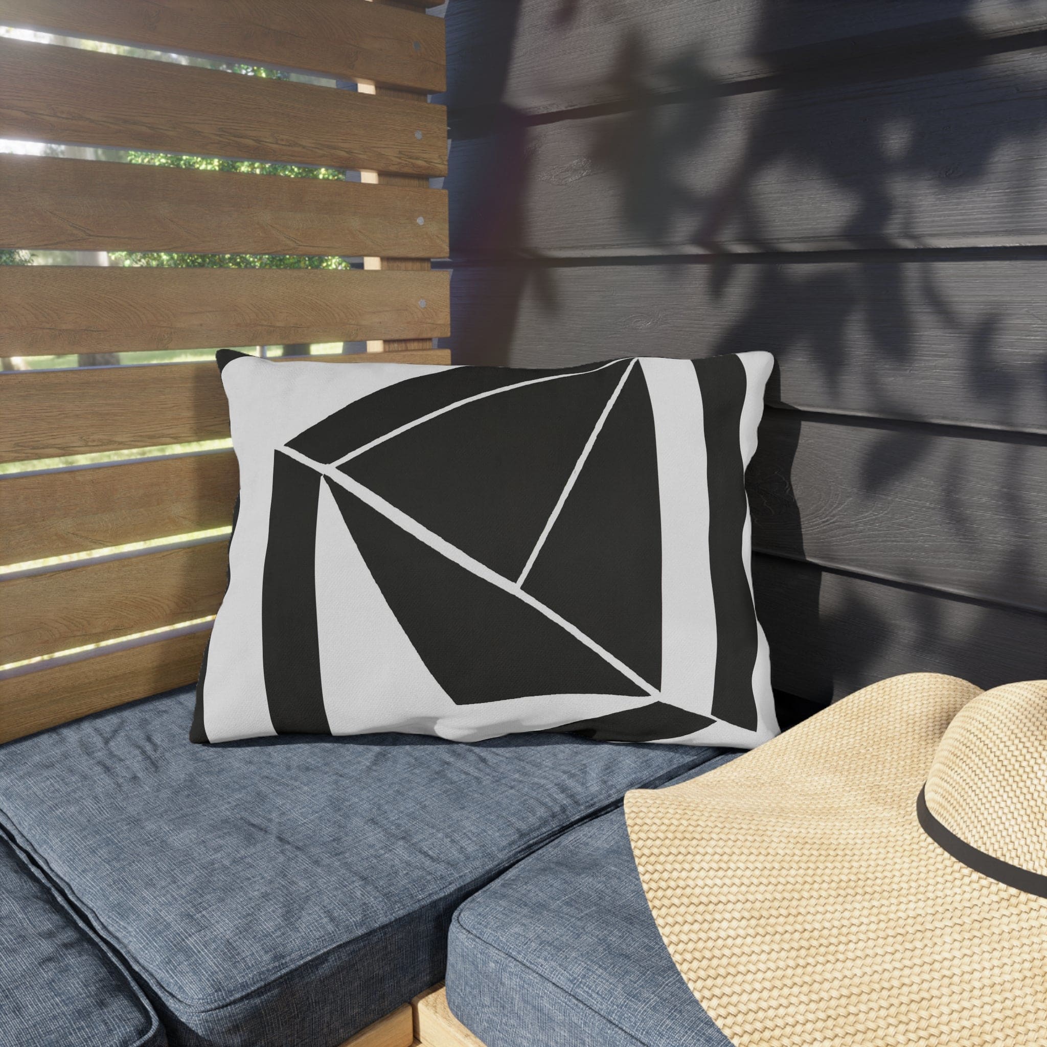 Decorative indoor/outdoor pillow featuring a black and white geometric pattern, ideal for enhancing outdoor spaces.