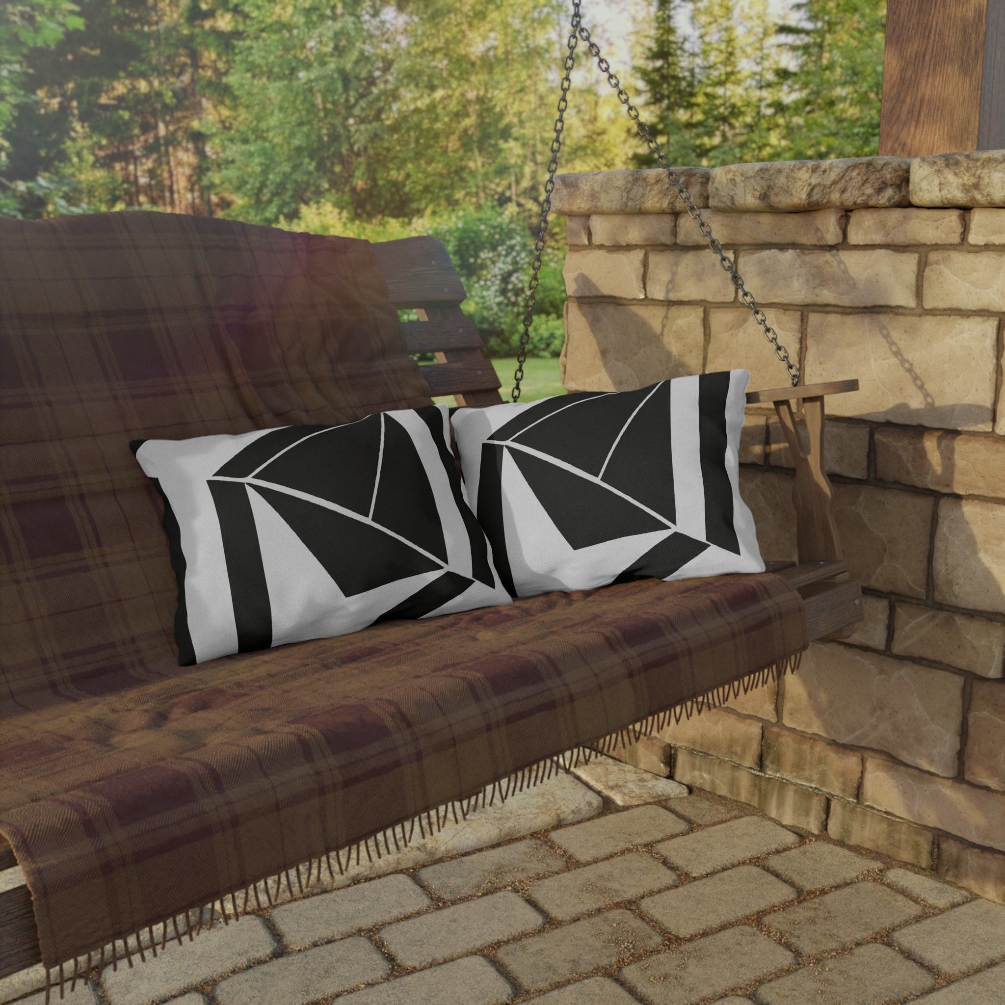 Decorative indoor/outdoor pillow featuring a black and white geometric pattern, ideal for enhancing outdoor spaces.