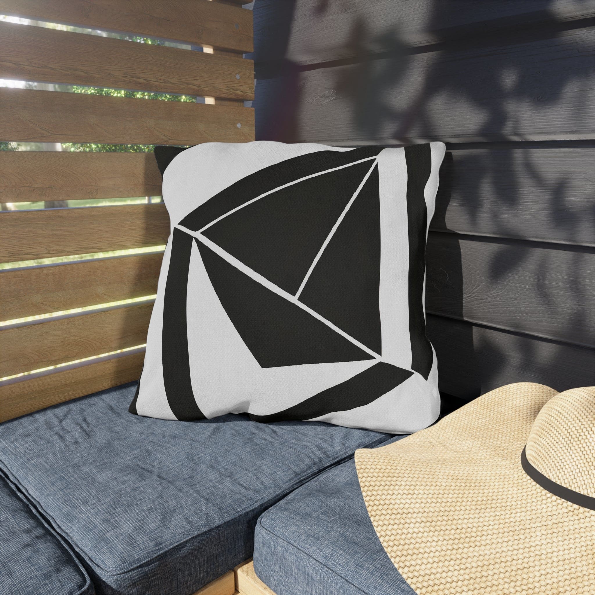 Decorative indoor/outdoor pillow featuring a black and white geometric pattern, ideal for enhancing outdoor spaces.