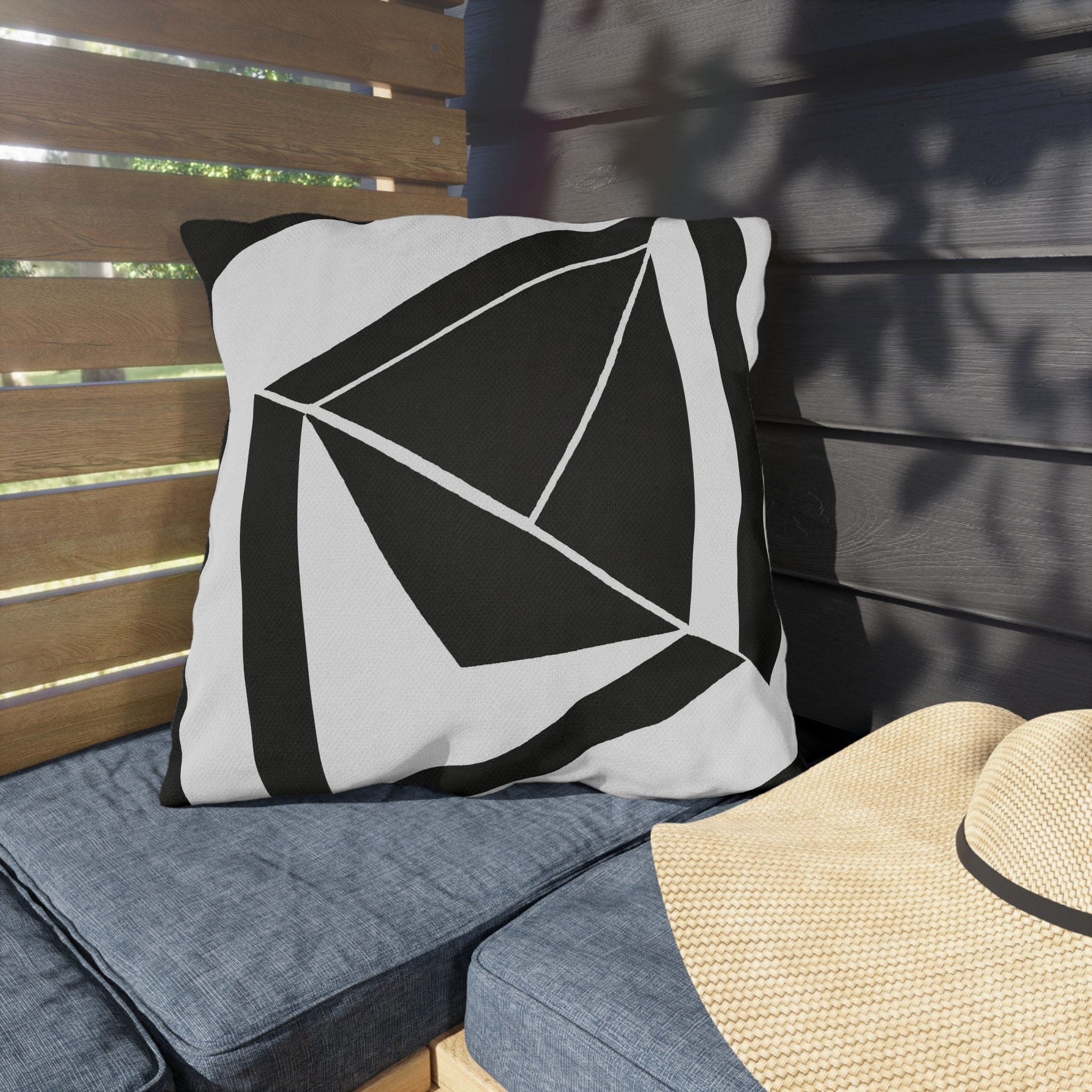 Decorative indoor/outdoor pillow featuring a black and white geometric pattern, ideal for enhancing outdoor spaces.