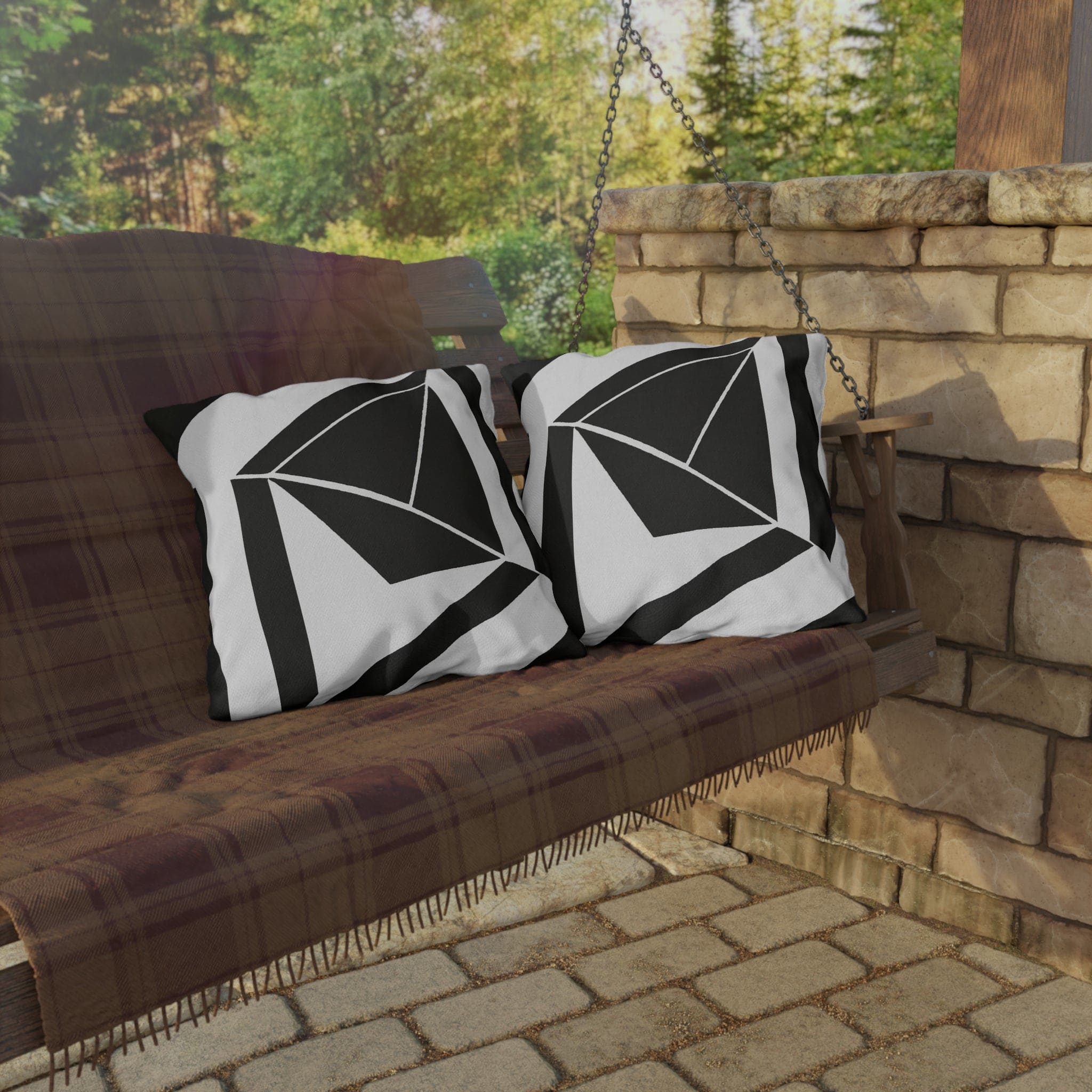 Decorative indoor/outdoor pillow featuring a black and white geometric pattern, ideal for enhancing outdoor spaces.