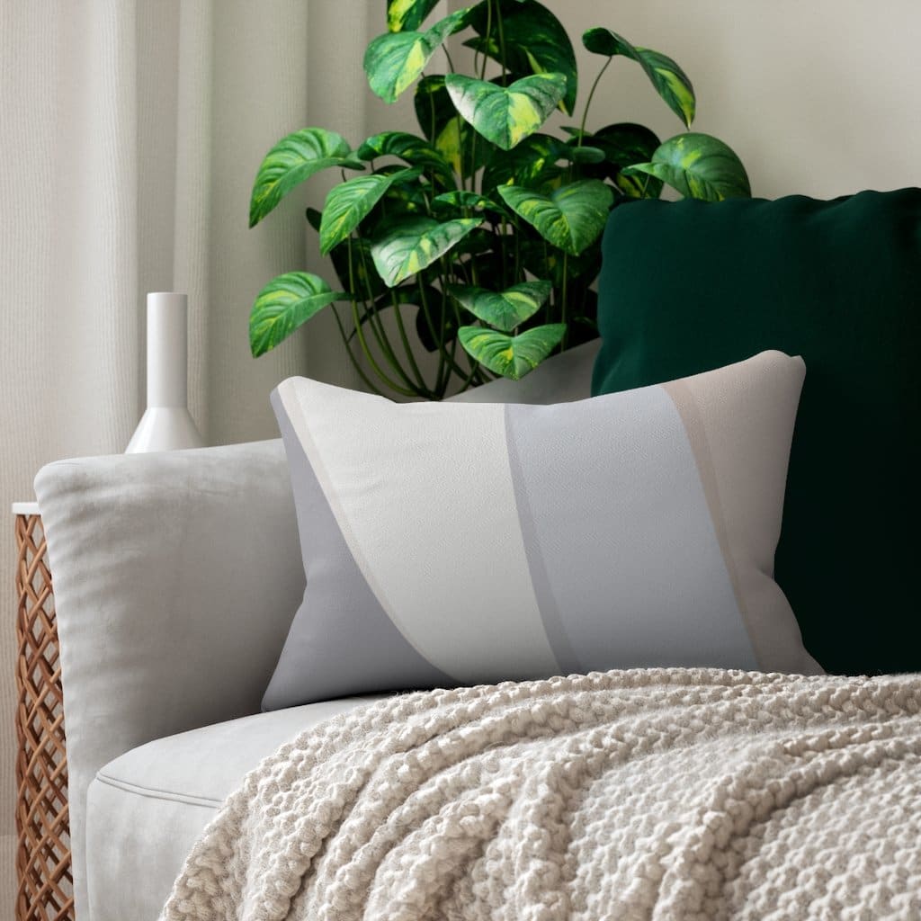 Decorative lumbar throw pillow featuring a geometric design in pink and grey colors, made from spun-polyester fabric with a hidden zipper.