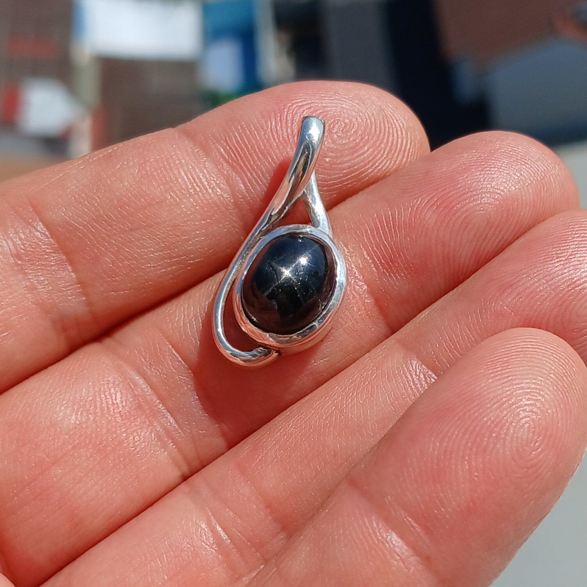 A stunning Black Star Diopside pendant in sterling silver, showcasing a unique 4-ray star pattern, elegantly crafted and hallmarked 925.