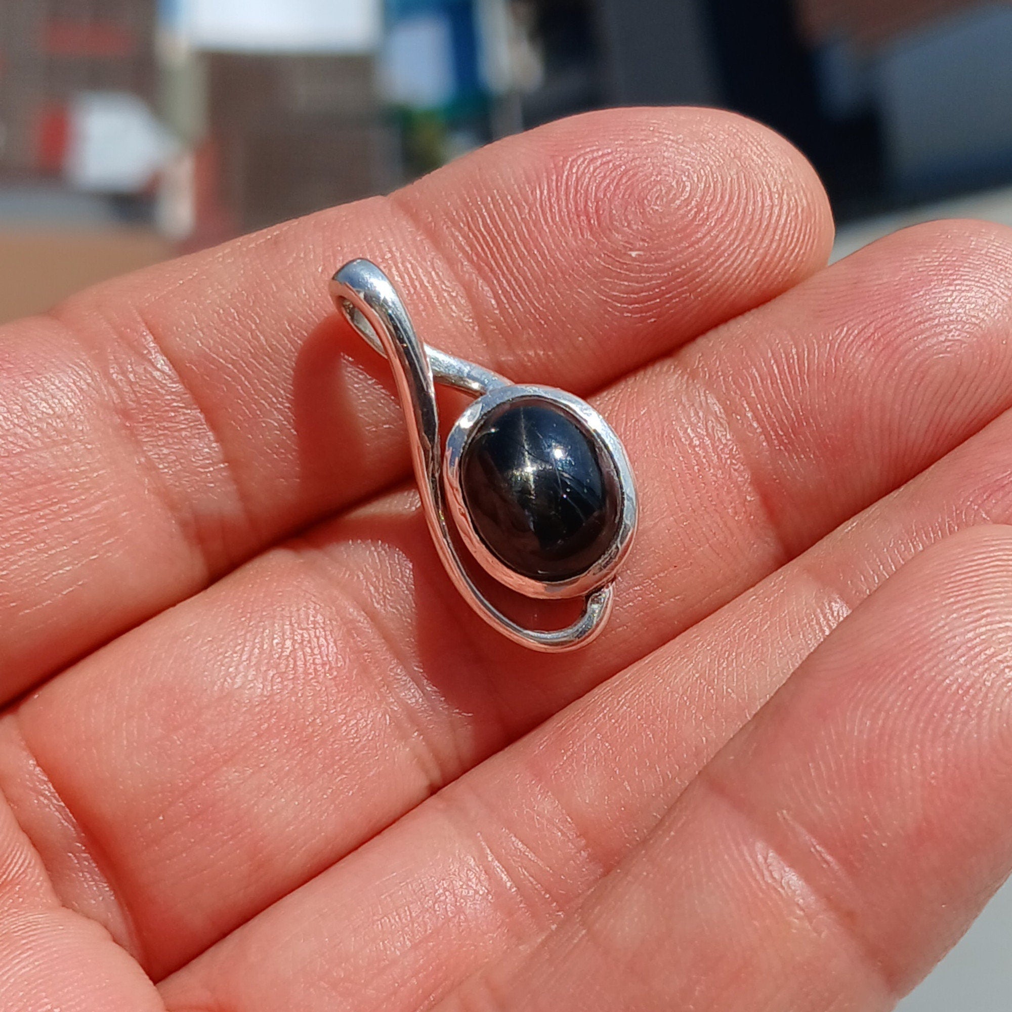 A stunning Black Star Diopside pendant in sterling silver, showcasing a unique 4-ray star pattern, elegantly crafted and hallmarked 925.