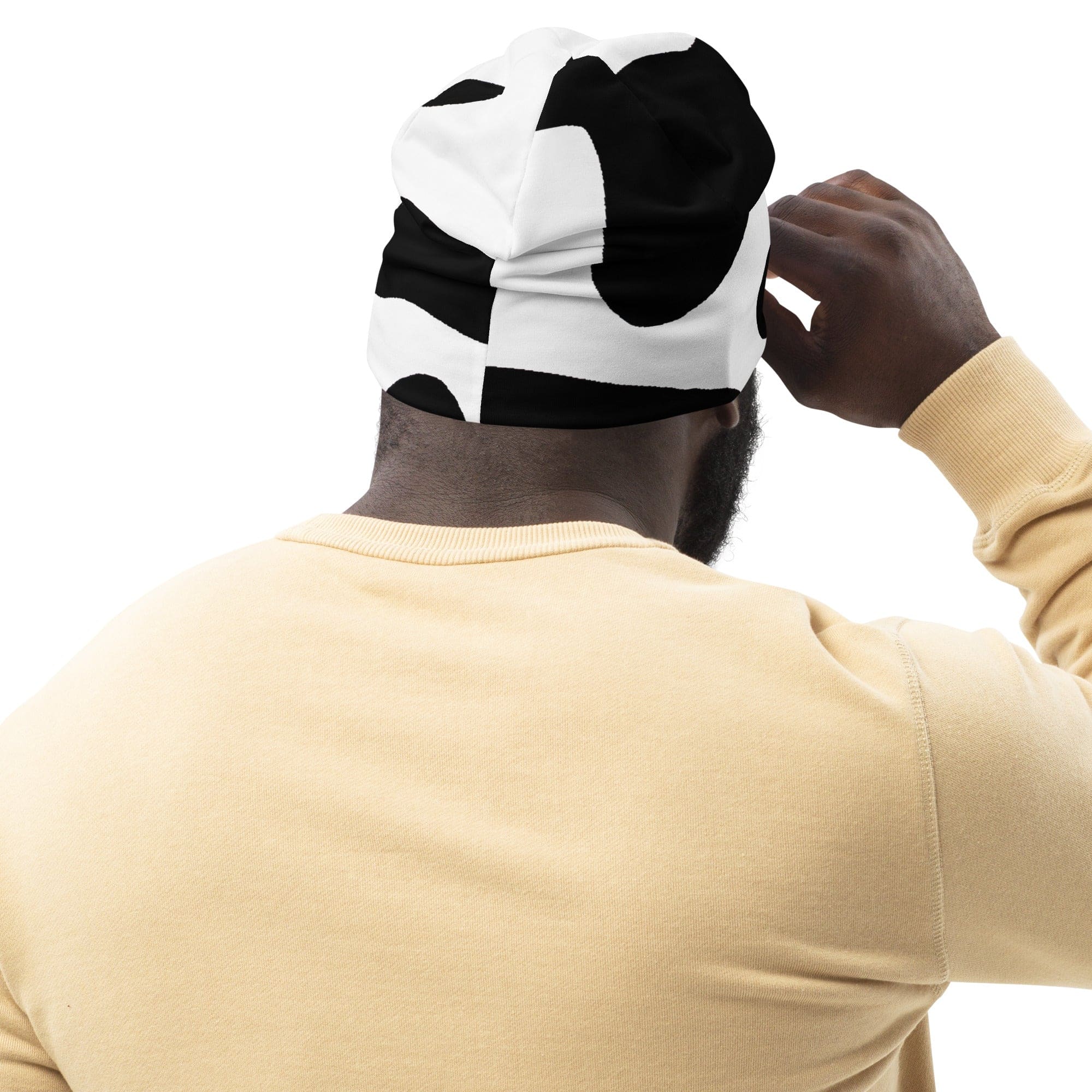 Double-layered beanie hat featuring a stylish black and white cow print design, perfect for winter and all seasons.