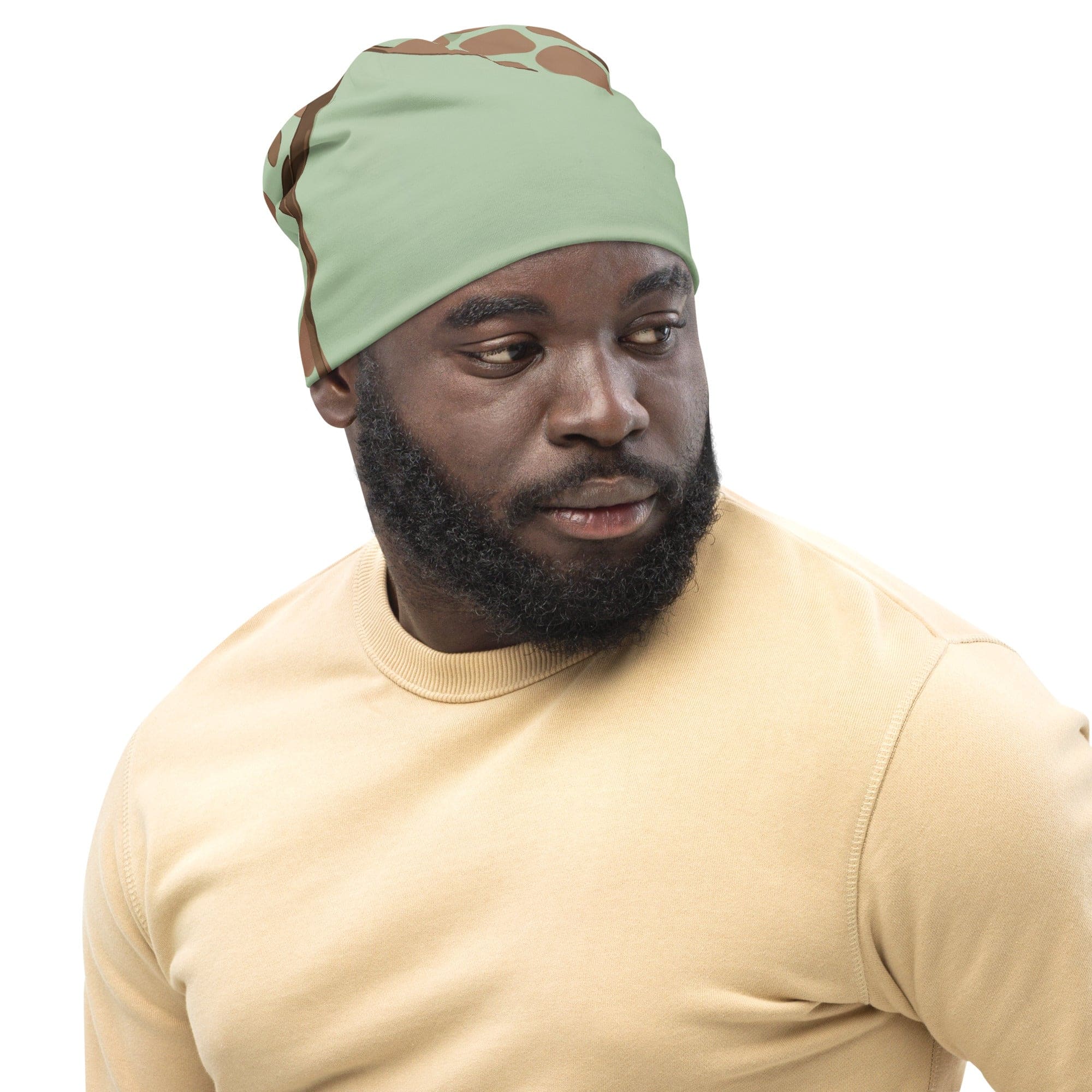 Double-layered beanie hat in green and beige spotted print, showcasing its soft fabric and stylish design.