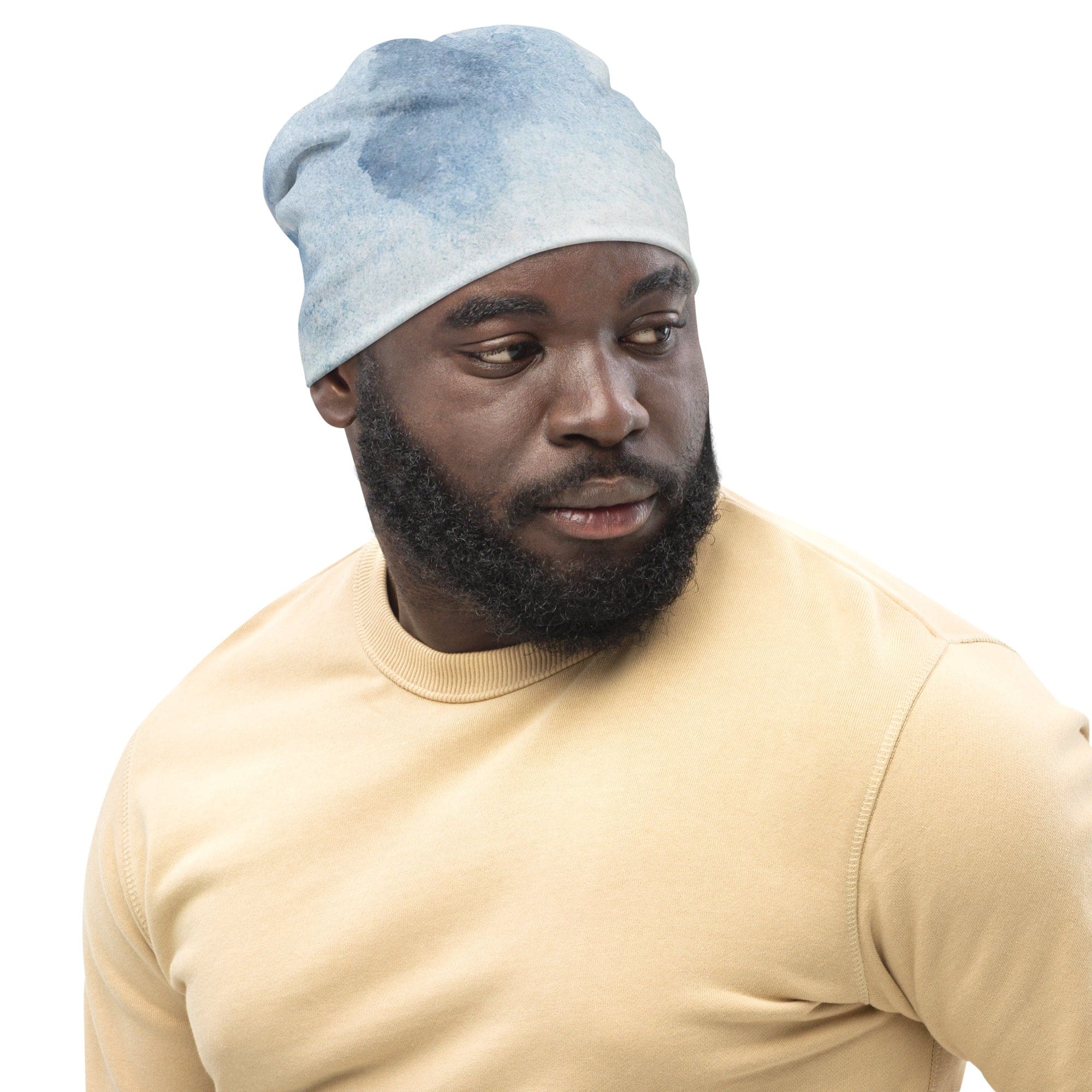 Double-layered beanie hat with green mountainside landscape and blue sky print, showcasing its stylish design and cozy fabric.