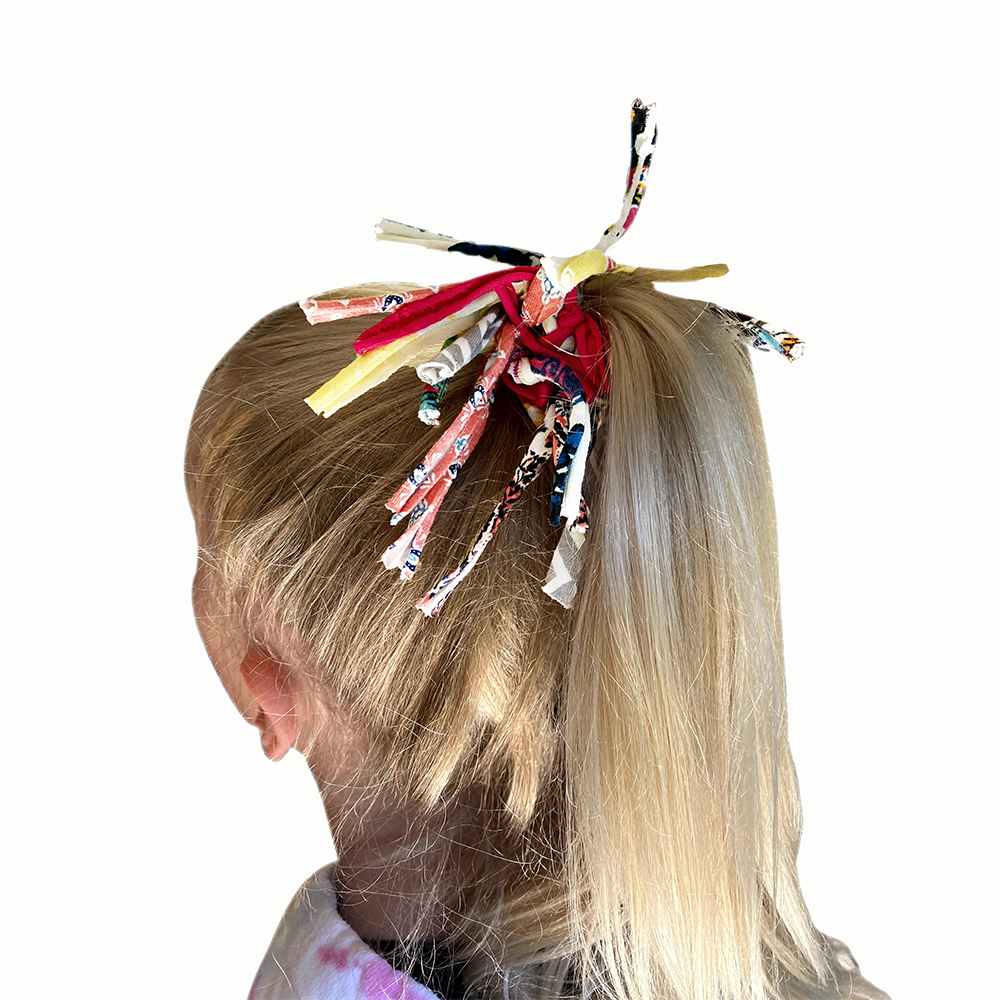 Eco DIY Scrunchie Kit featuring colorful upcycled materials and hair ties for crafting stylish scrunchies.