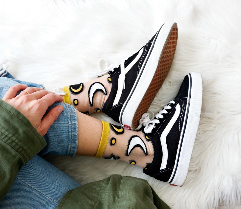 A pair of stylish embroidered mesh ankle socks featuring celestial designs with moons, stars, and botanical motifs in lavender and sunshine yellow trims.