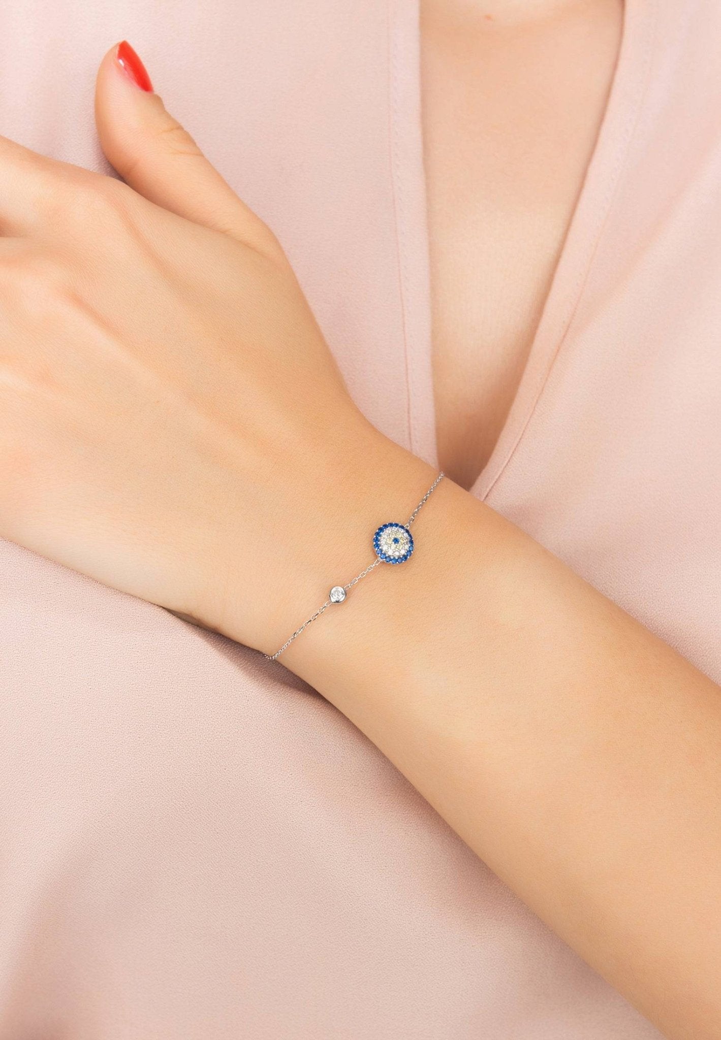 Elegant silver Evil Eye bracelet adorned with blue and white zircons, featuring a lobster clasp and adjustable length.