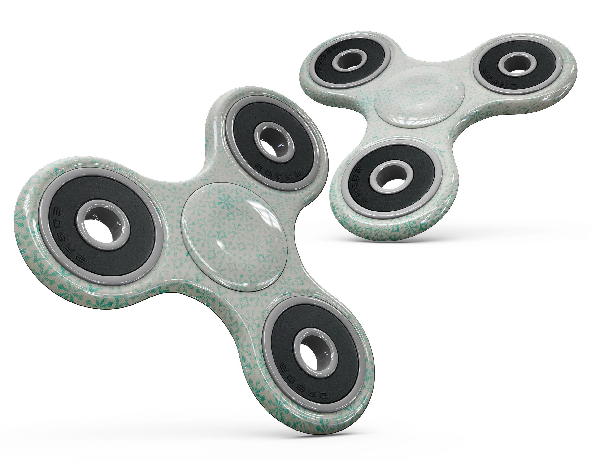 Faded teal fidget spinner skin kit featuring a snowflake pattern, showcasing vibrant colors and a sleek design.
