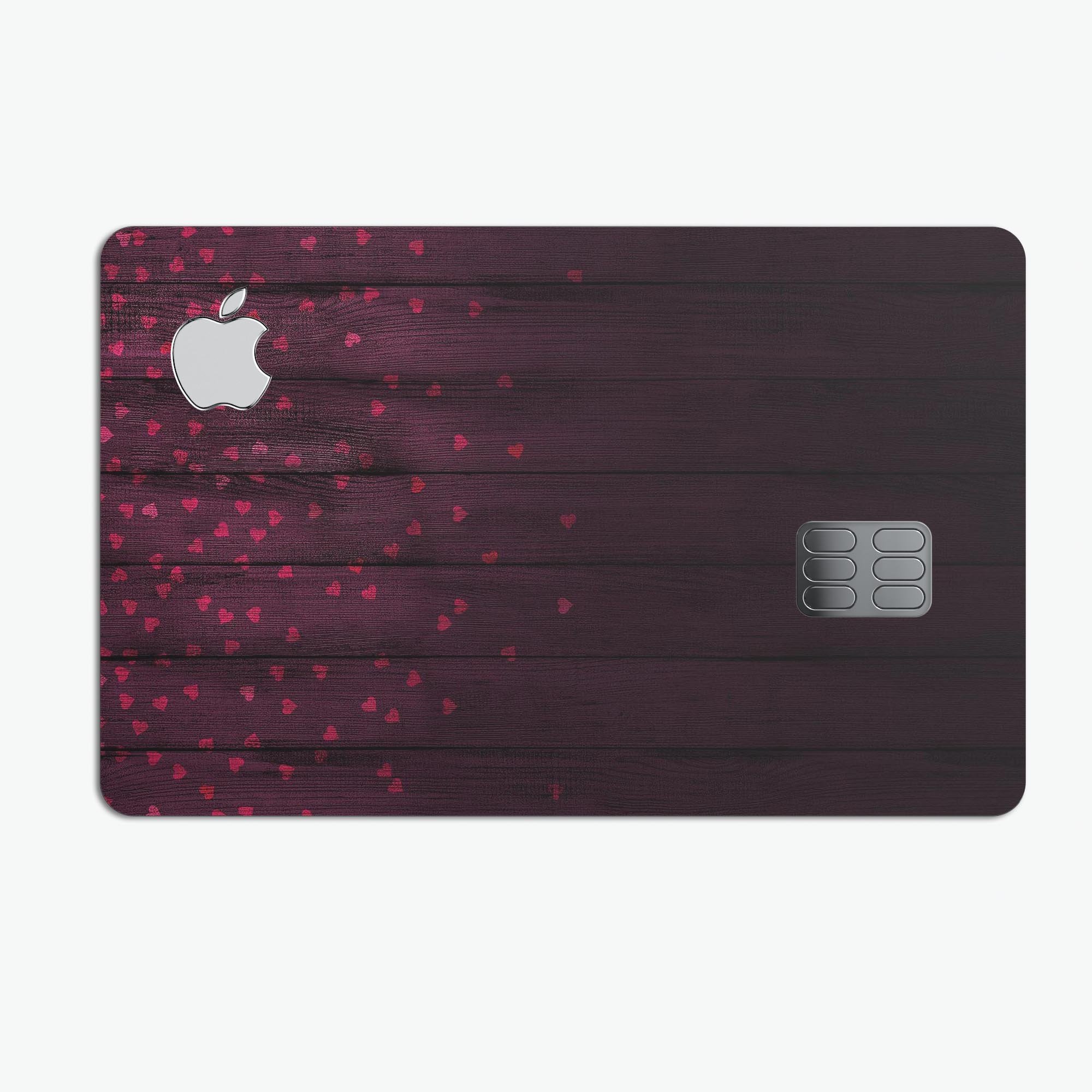 Falling Micro Hearts skin design on burgundy wood background, showcasing premium protective vinyl for Apple Card.