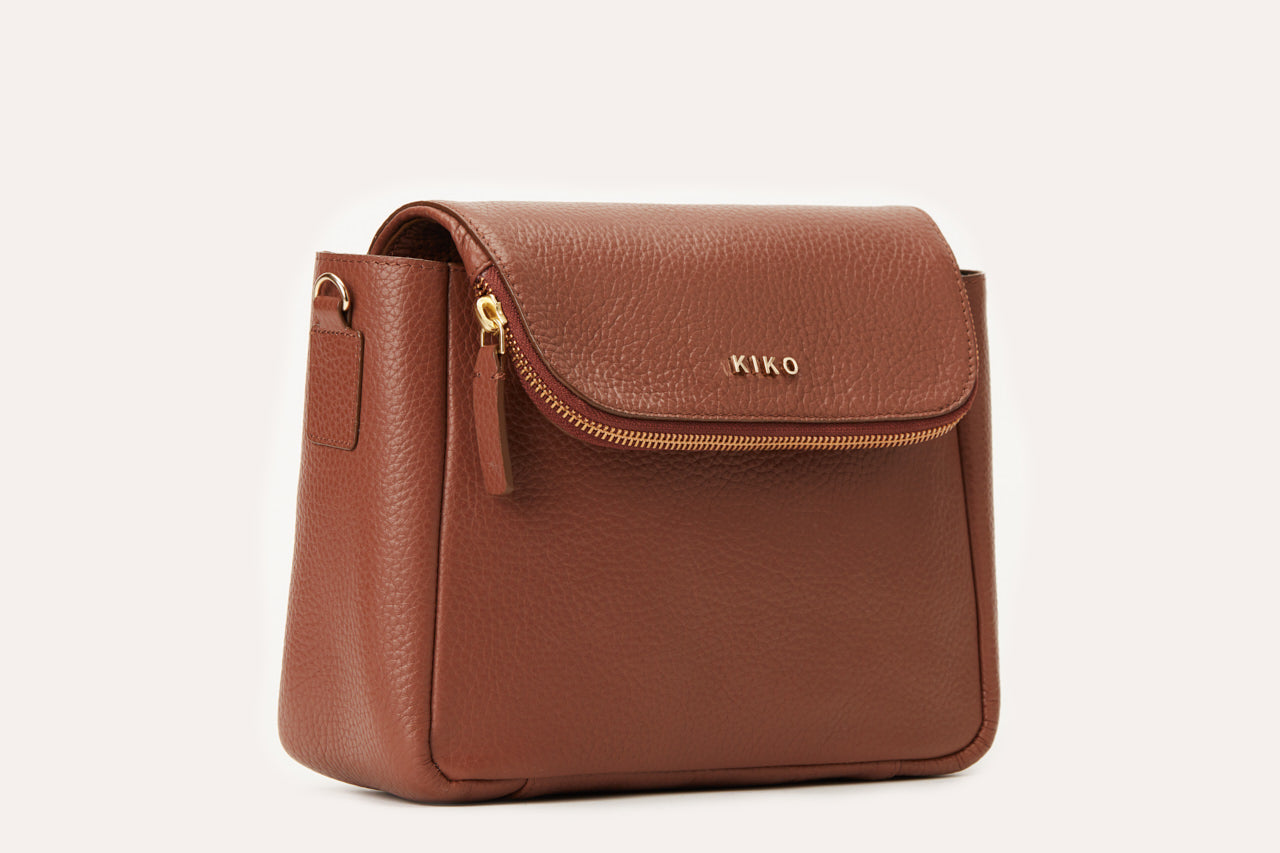 Fold Over Crossbody bag made of genuine pebble leather with a magnetic closure and adjustable strap.