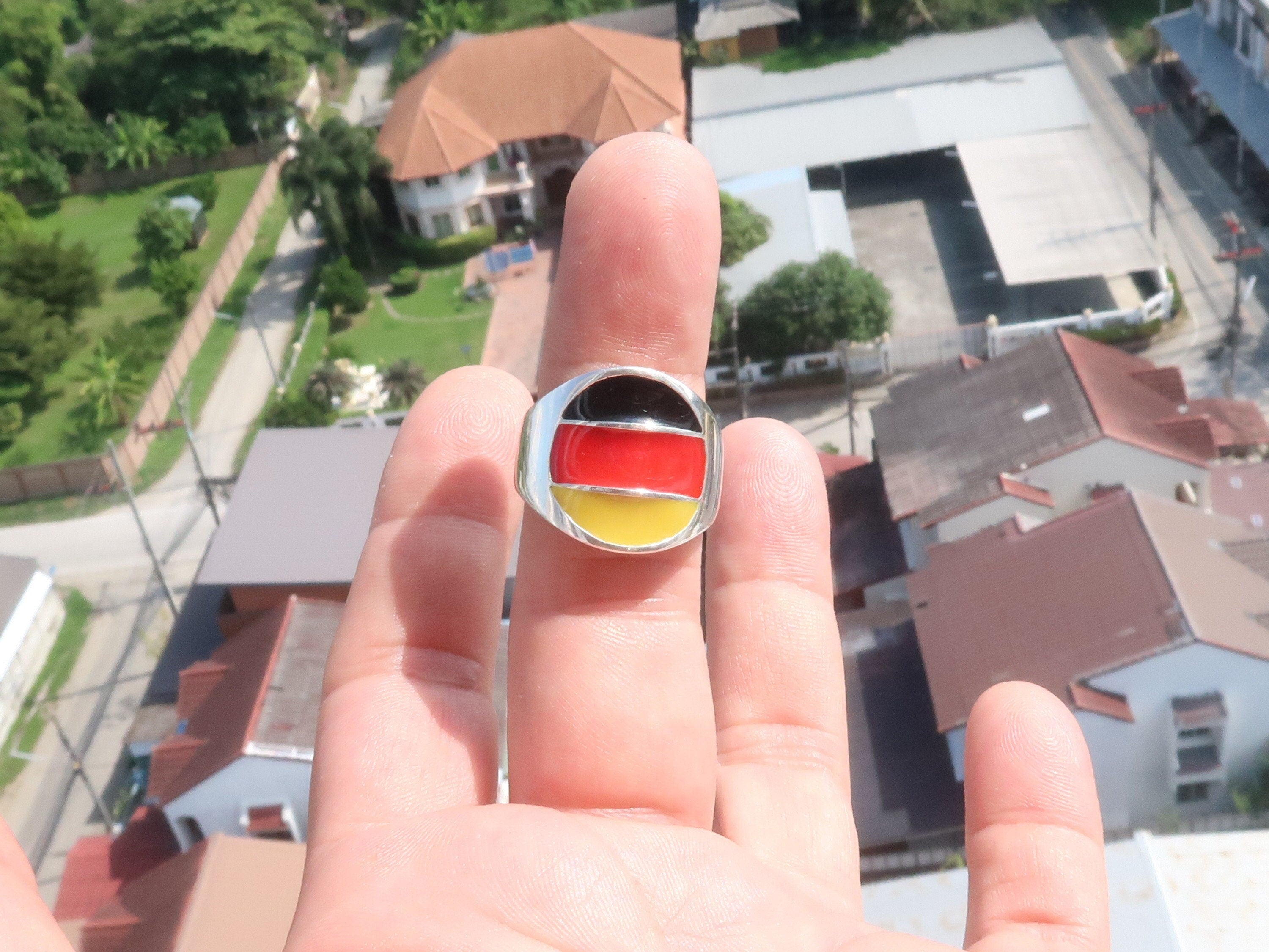 A stylish German Flag Ring made of polished sterling silver, featuring the colors of the German flag in a round pinky ring design.